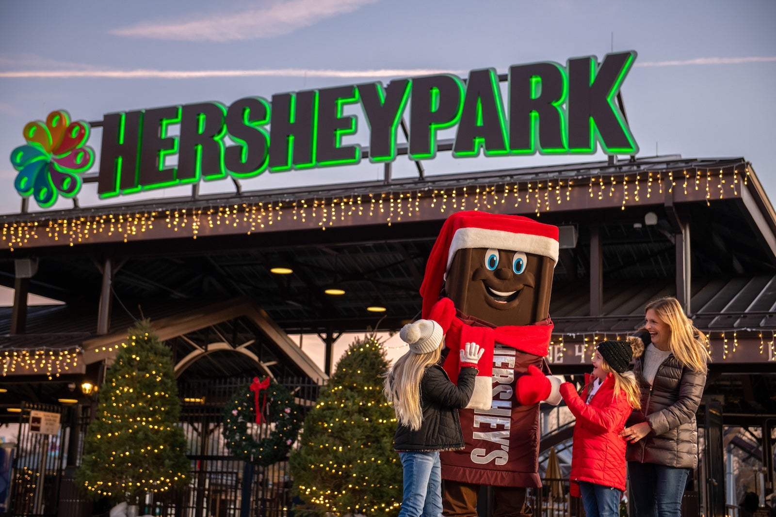 A family posing with the Hershey mascot for a holiday photo