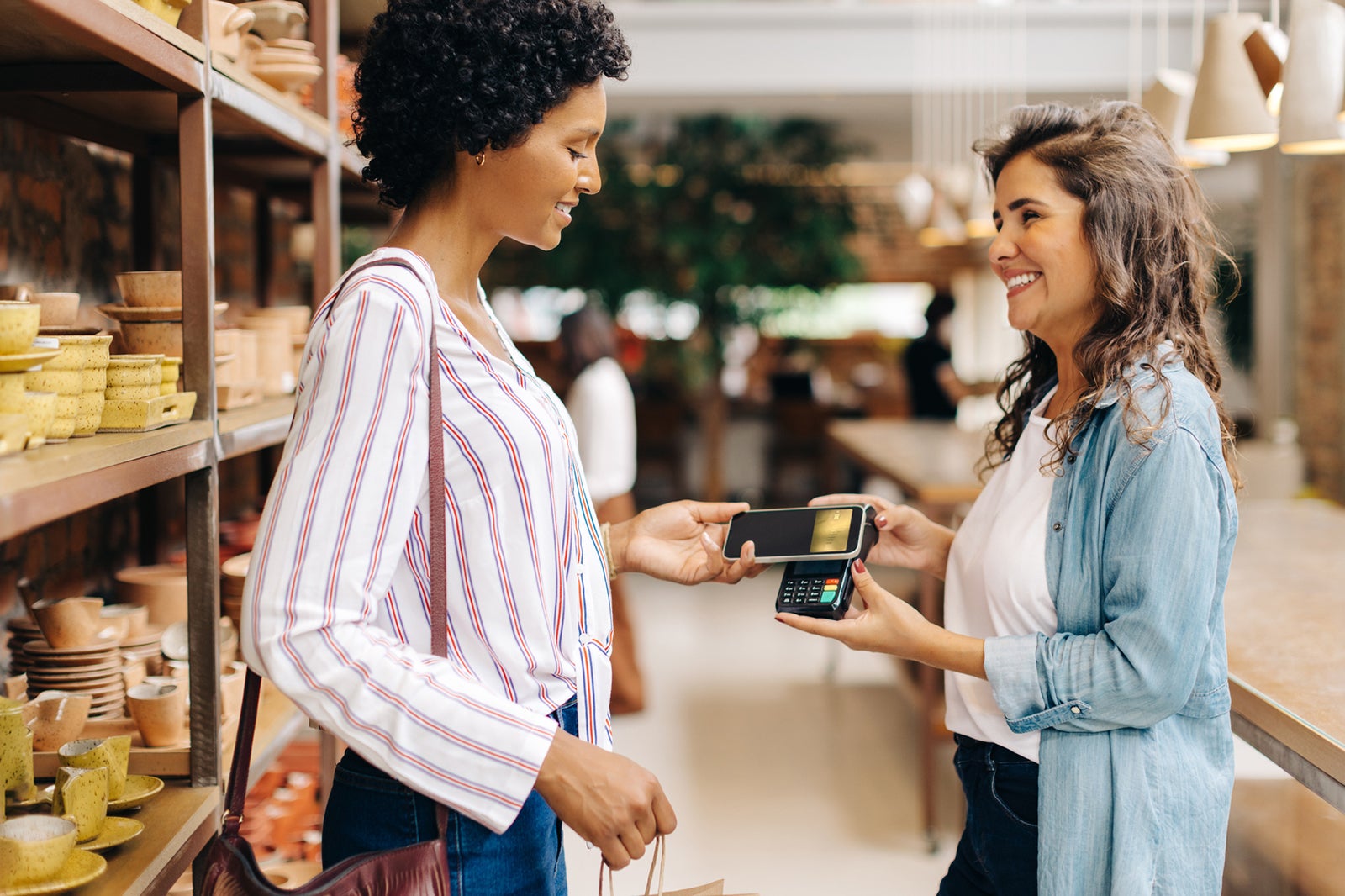 A woman paying via contactless payment with her phone