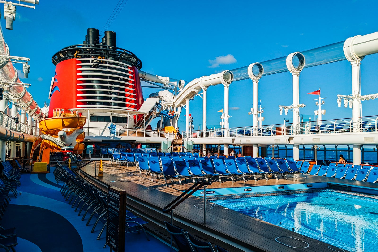 Disney Dream cruise ship pool deck with clear water slide tube running around it 