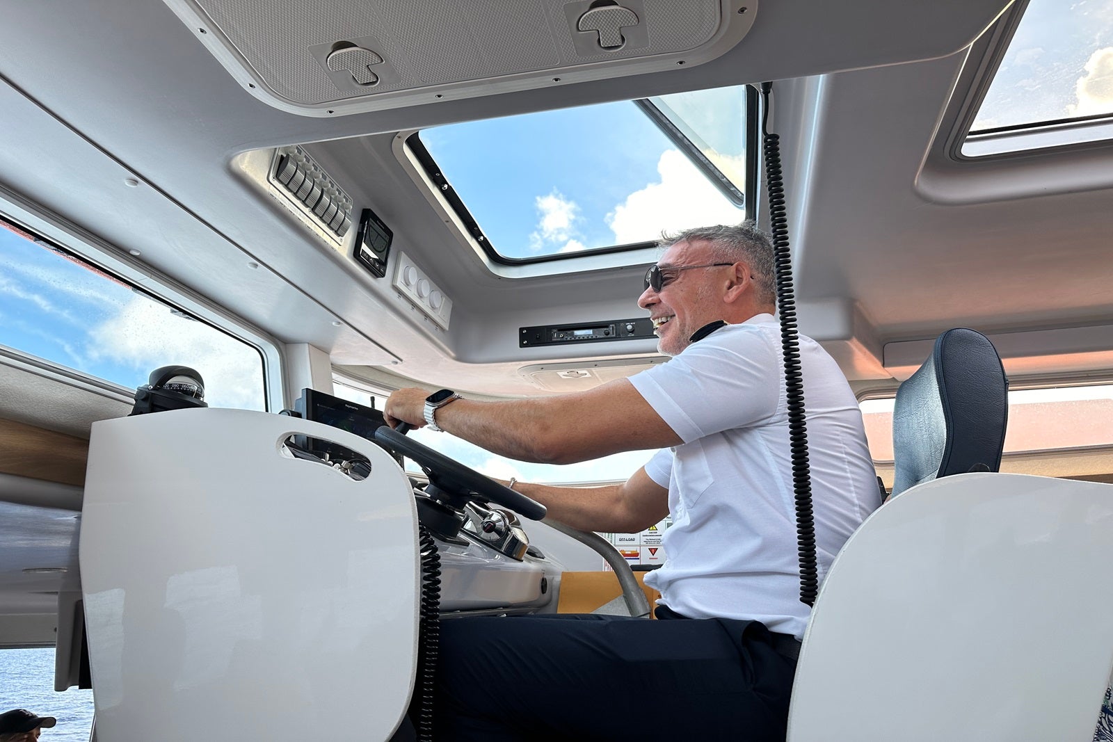 A captain sitting in the driver's seat inside a lifeboat