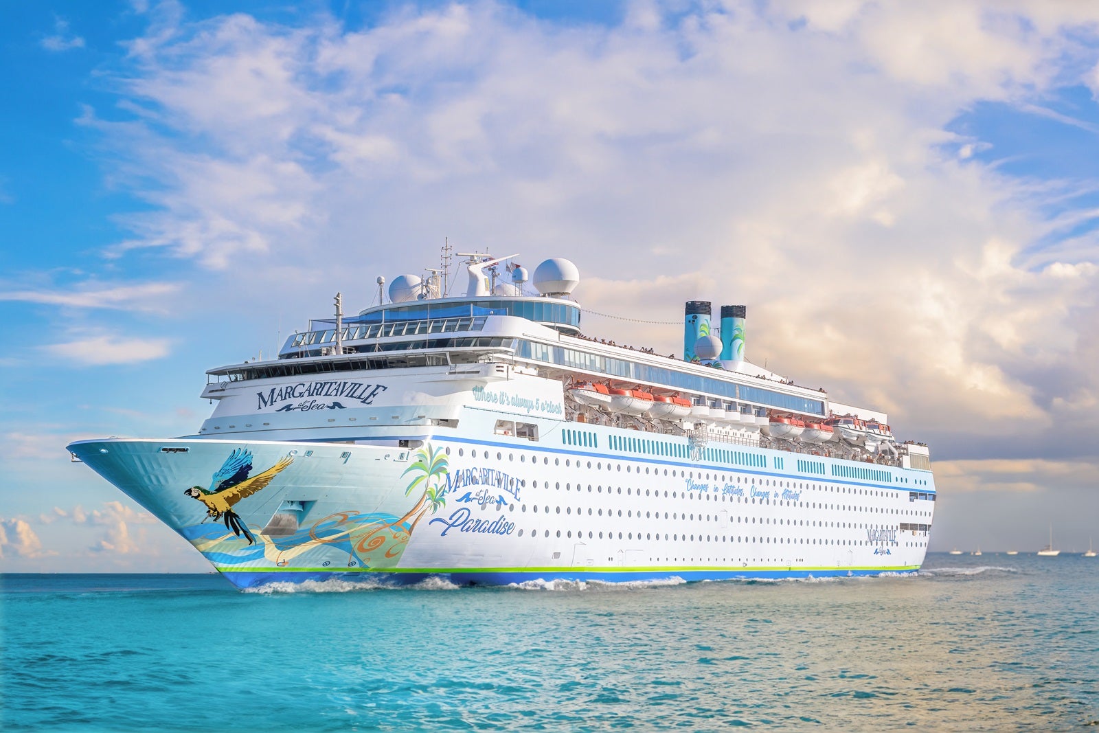 A cruise ship with a bird painted on the hull floats on teal-blue water with a purple sky and clouds behind it