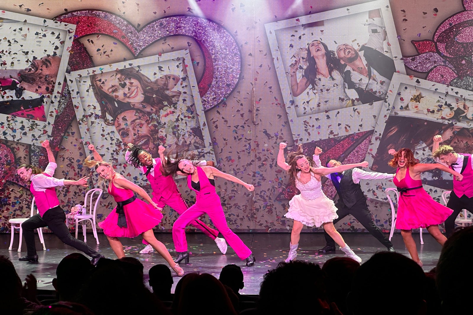 Dancers in pink costumes perform on stage on a cruise ship