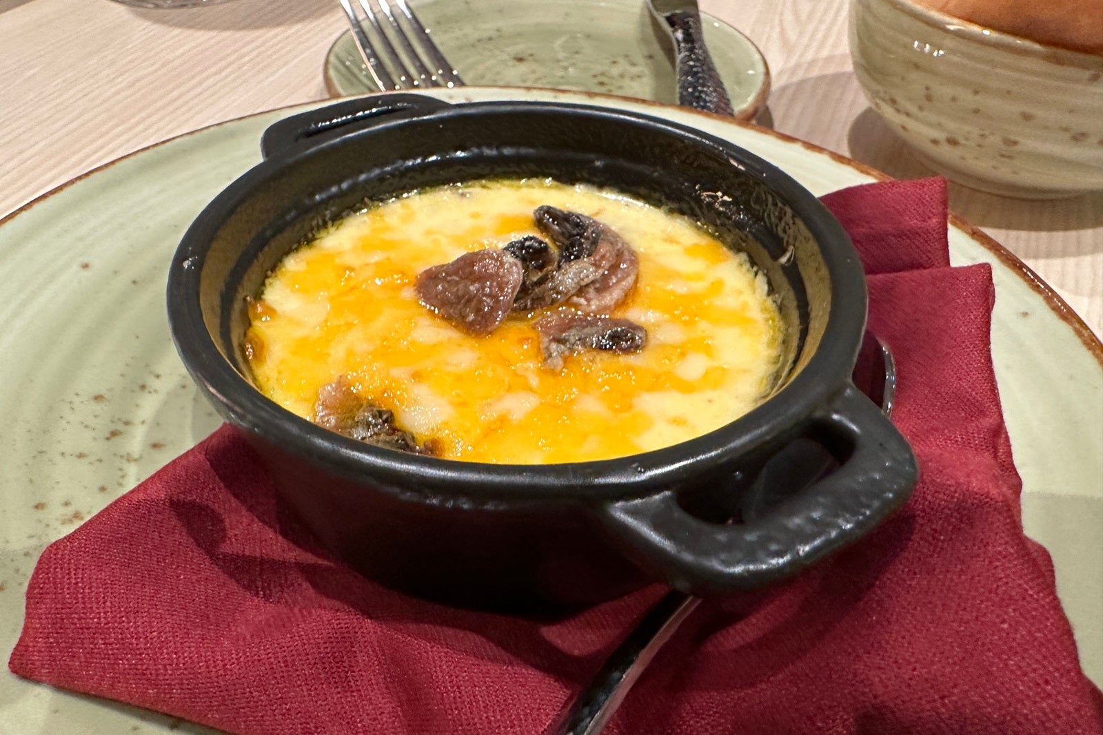 A small black cast iron dish filled with queso fundido