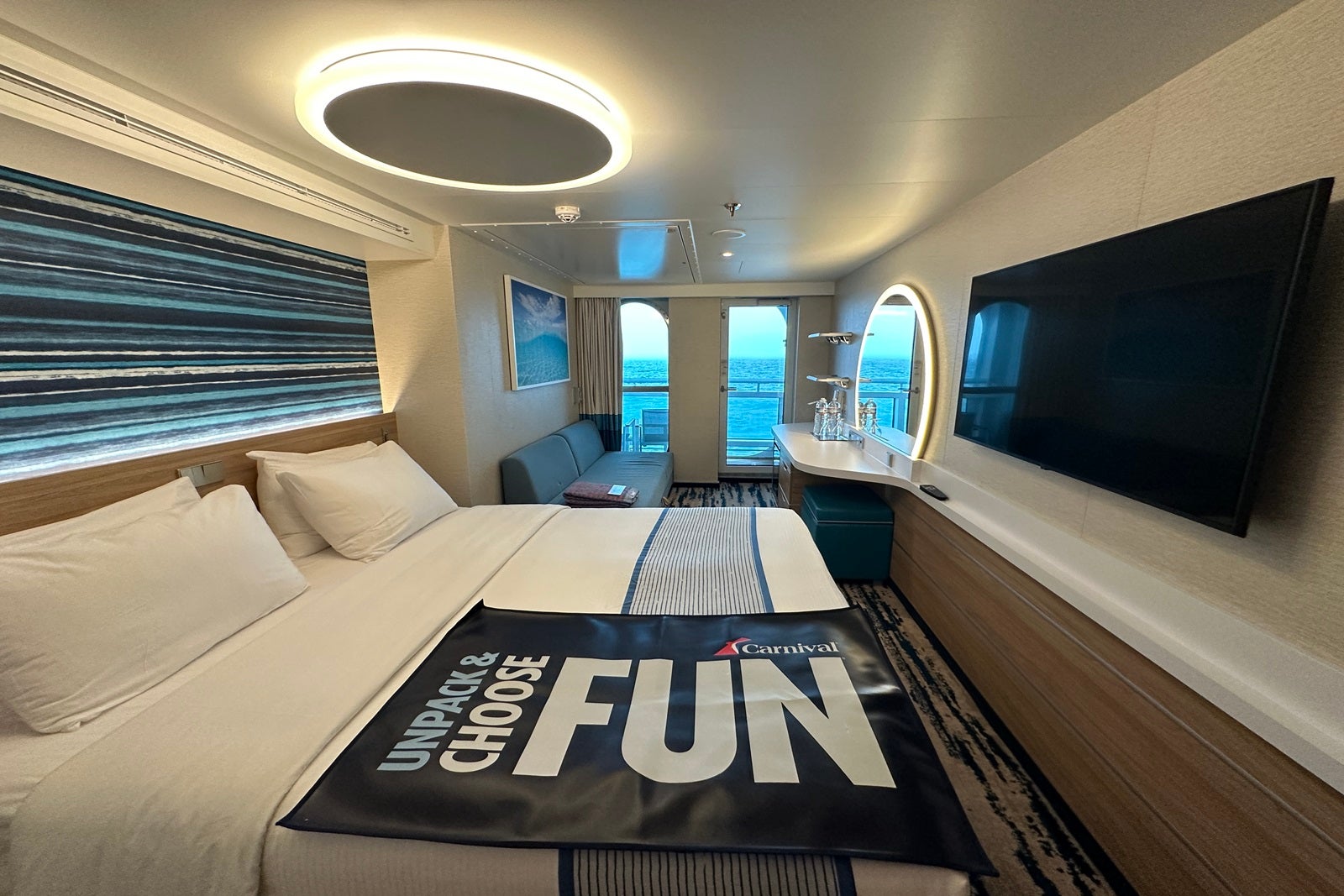 A cruise ship cabin with a luggage unpacking mat