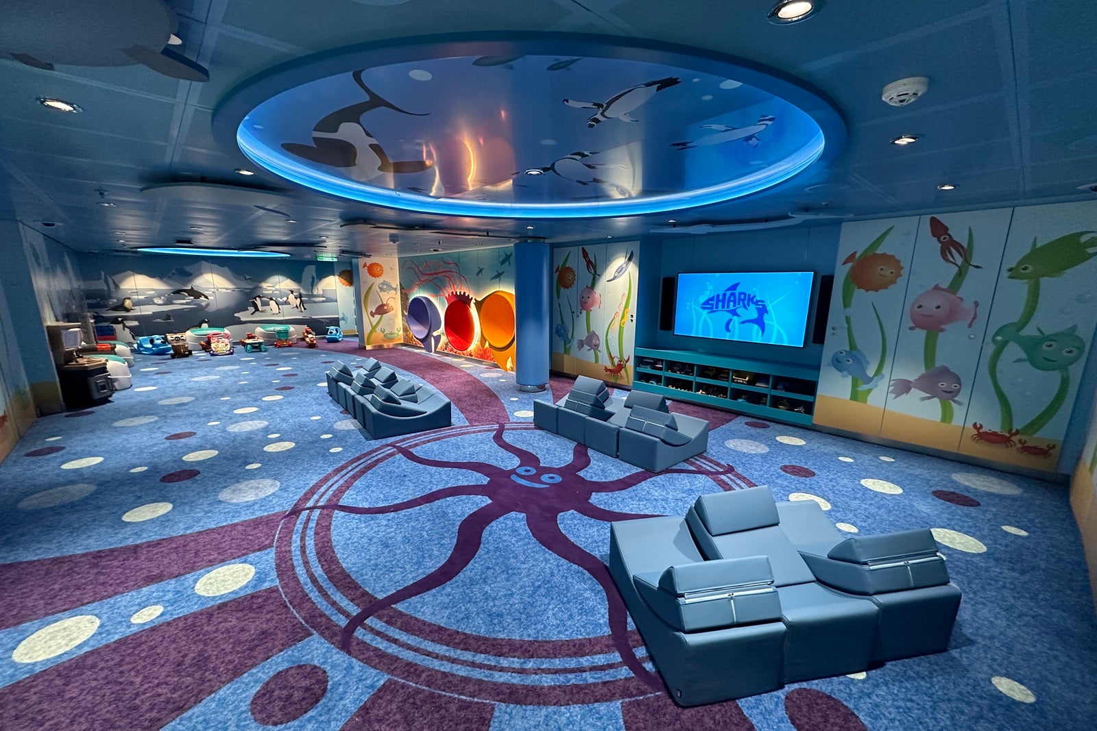 A large room with seating alcoves, a TV and activity areas for kids