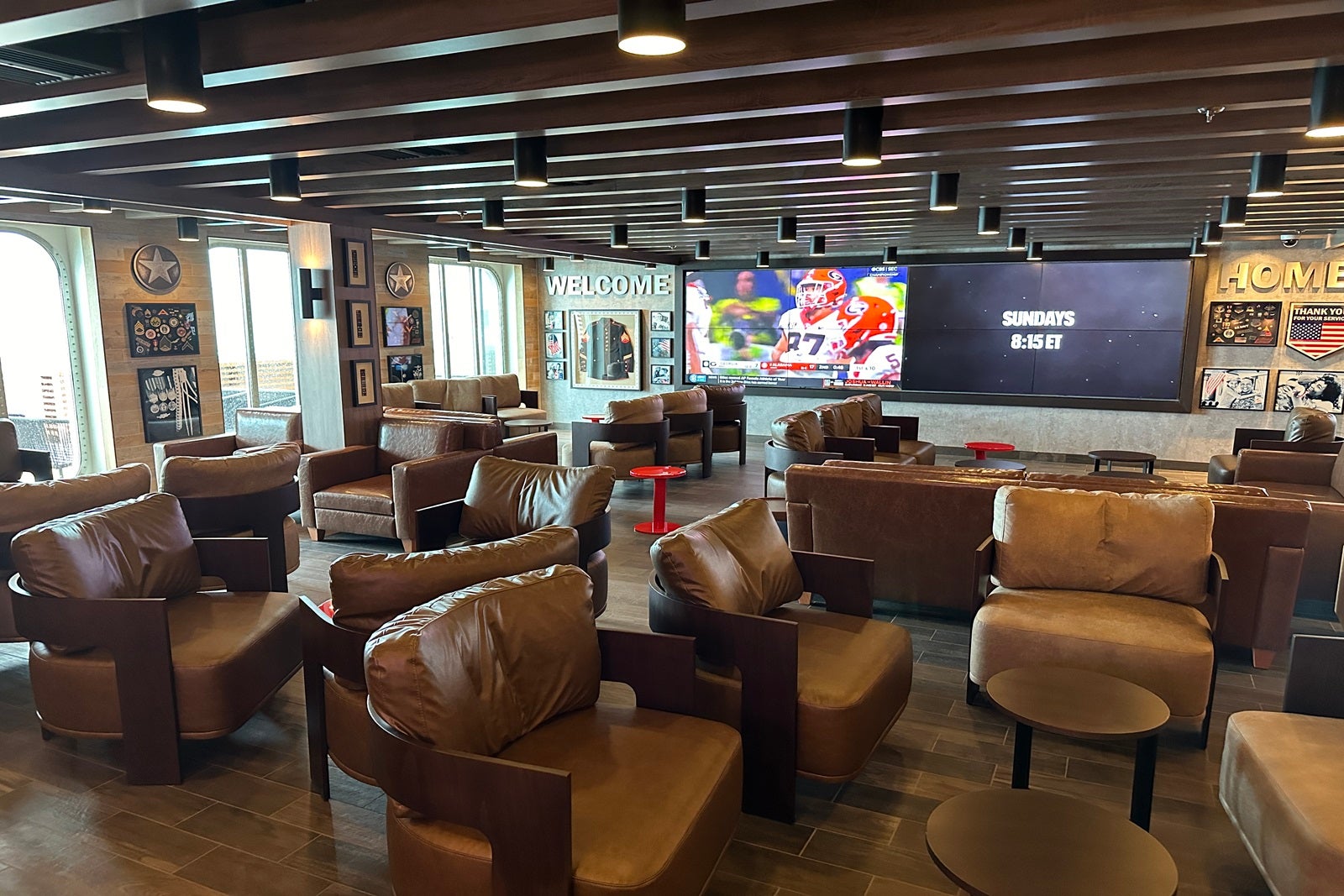 A cozy lounge with TVs, leather chairs and sofas, and miltary memorabilia