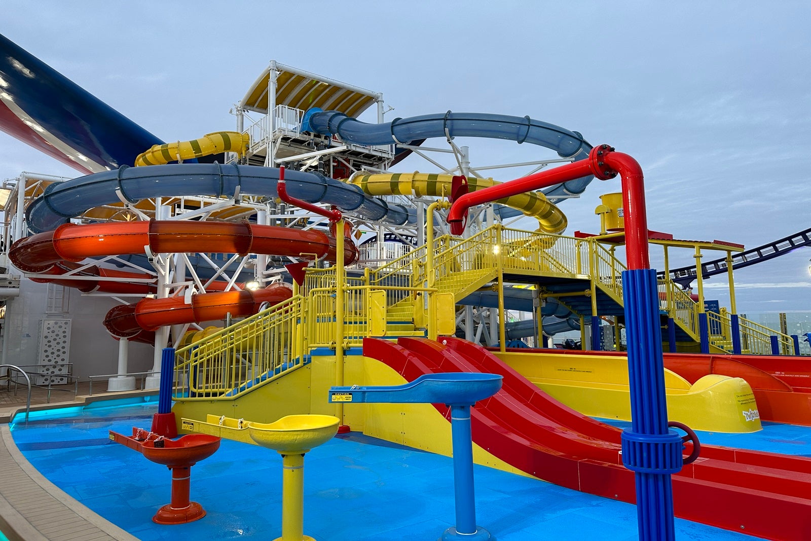 A tangle of colorful waterslides on the top deck of a cruise ship
