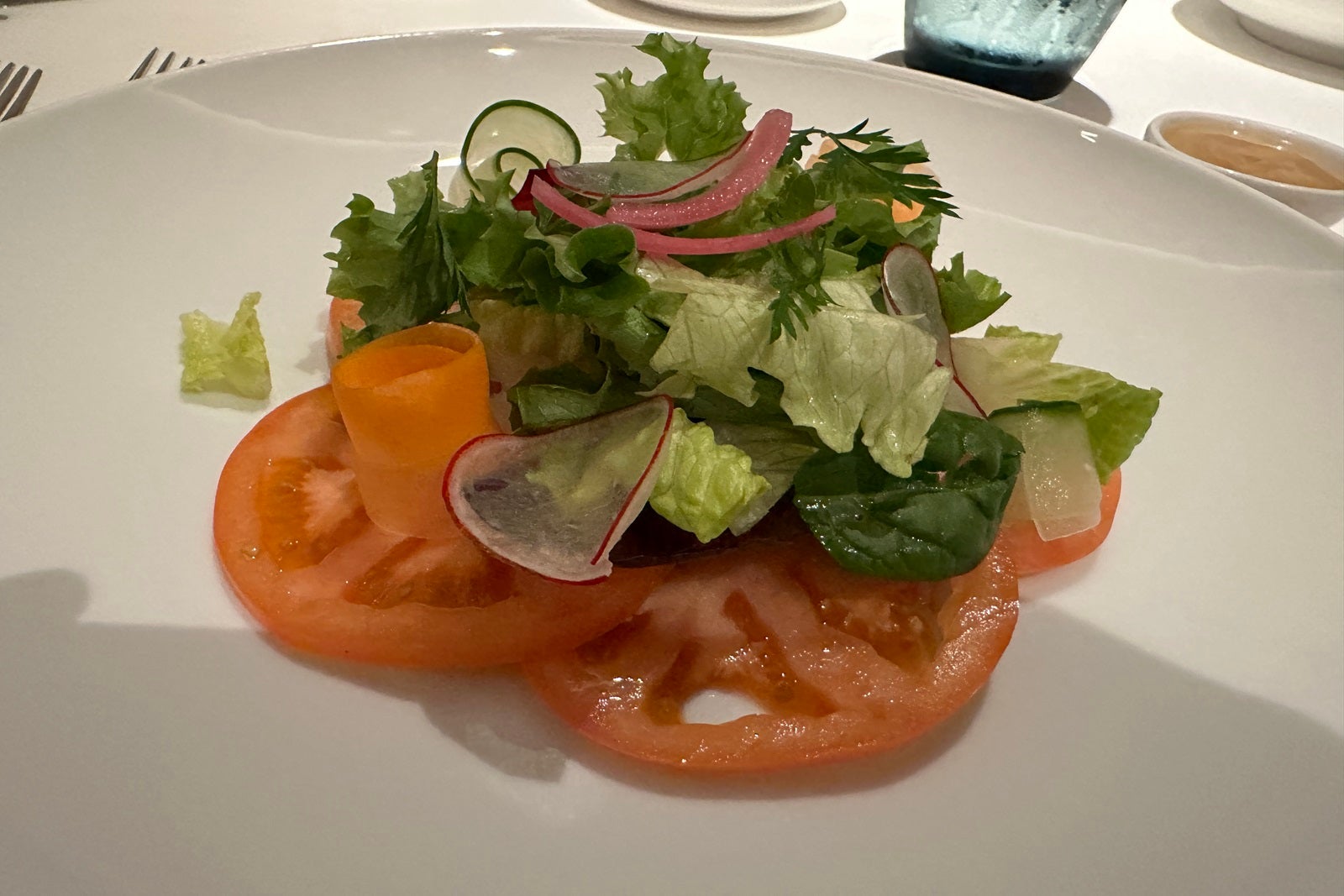 A salad with lettuce and tomatoes on a white plate