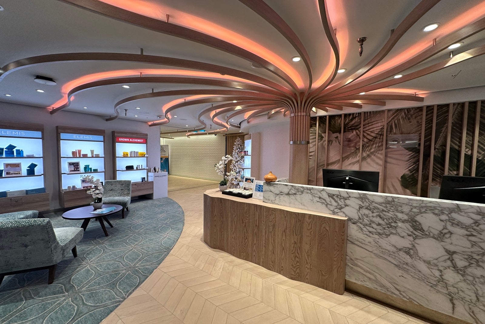 The reception area of a spa with a front desk, a waiting area and retail shelves stocked with products