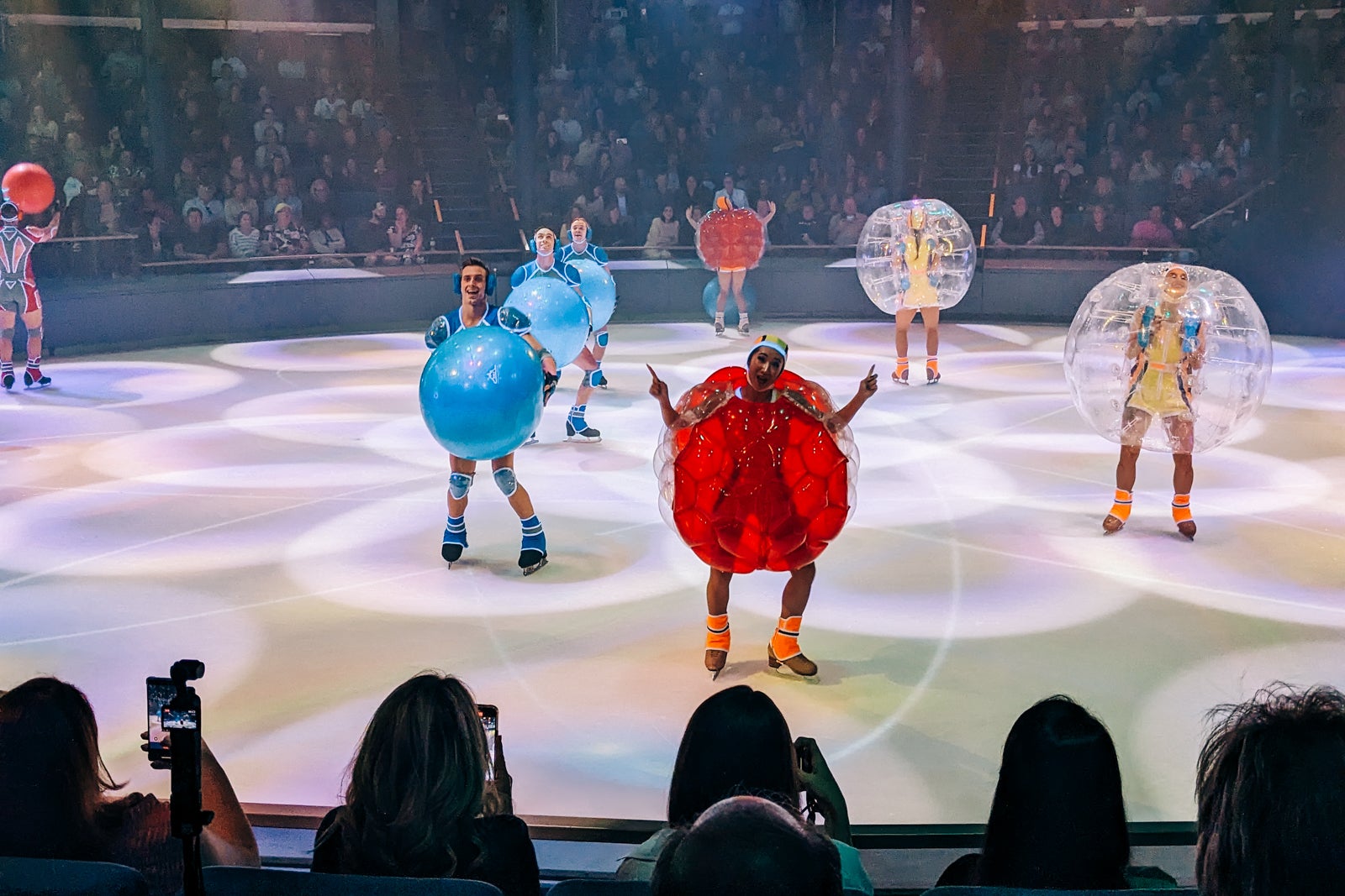 Ice skaters dressed as atoms during a performance on a cruise ship