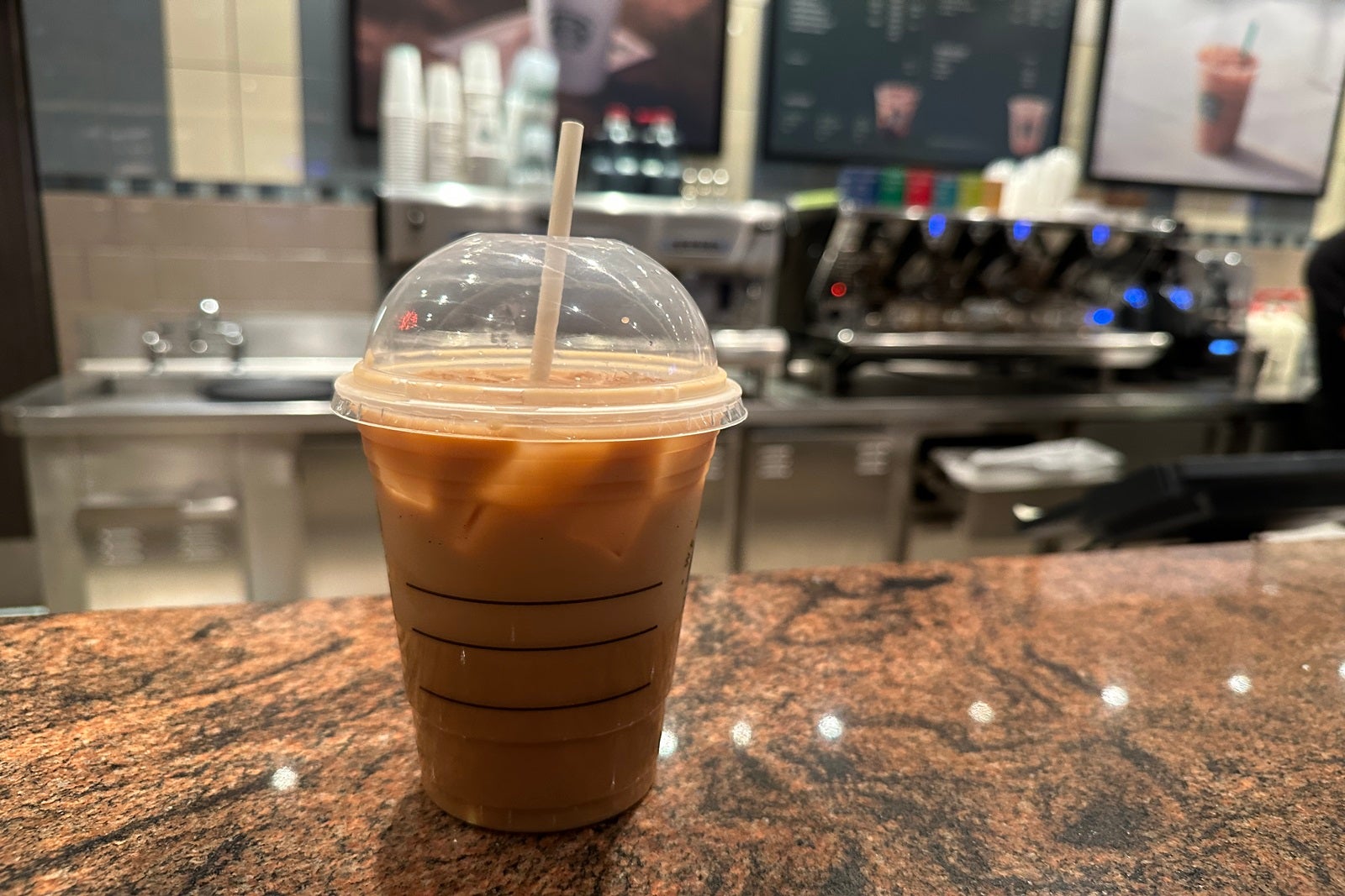 An iced coffee sitting on a cafe counter