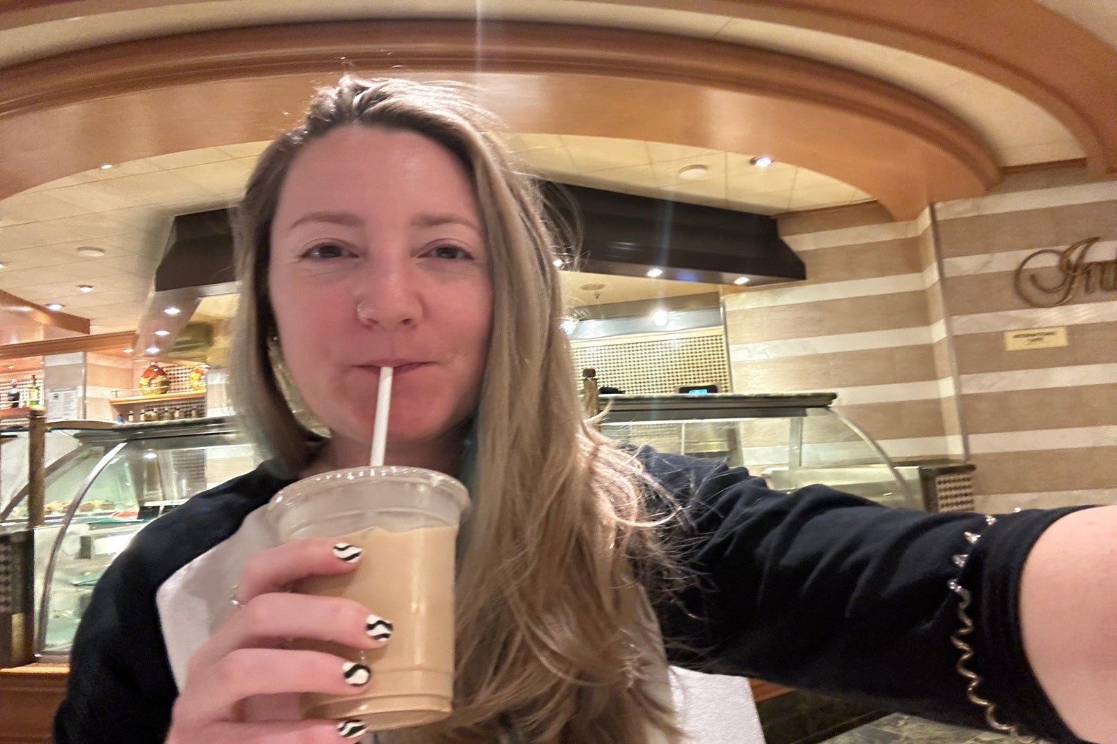 A woman holding an iced coffee