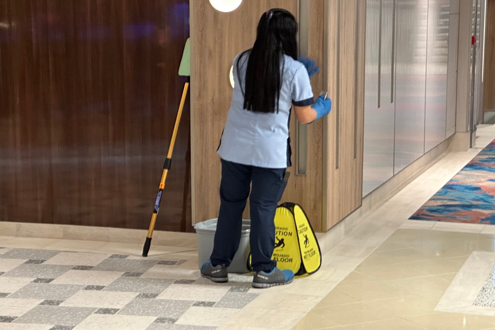 A cruise ship crew member does some final spot cleaning before the debut of a new ship