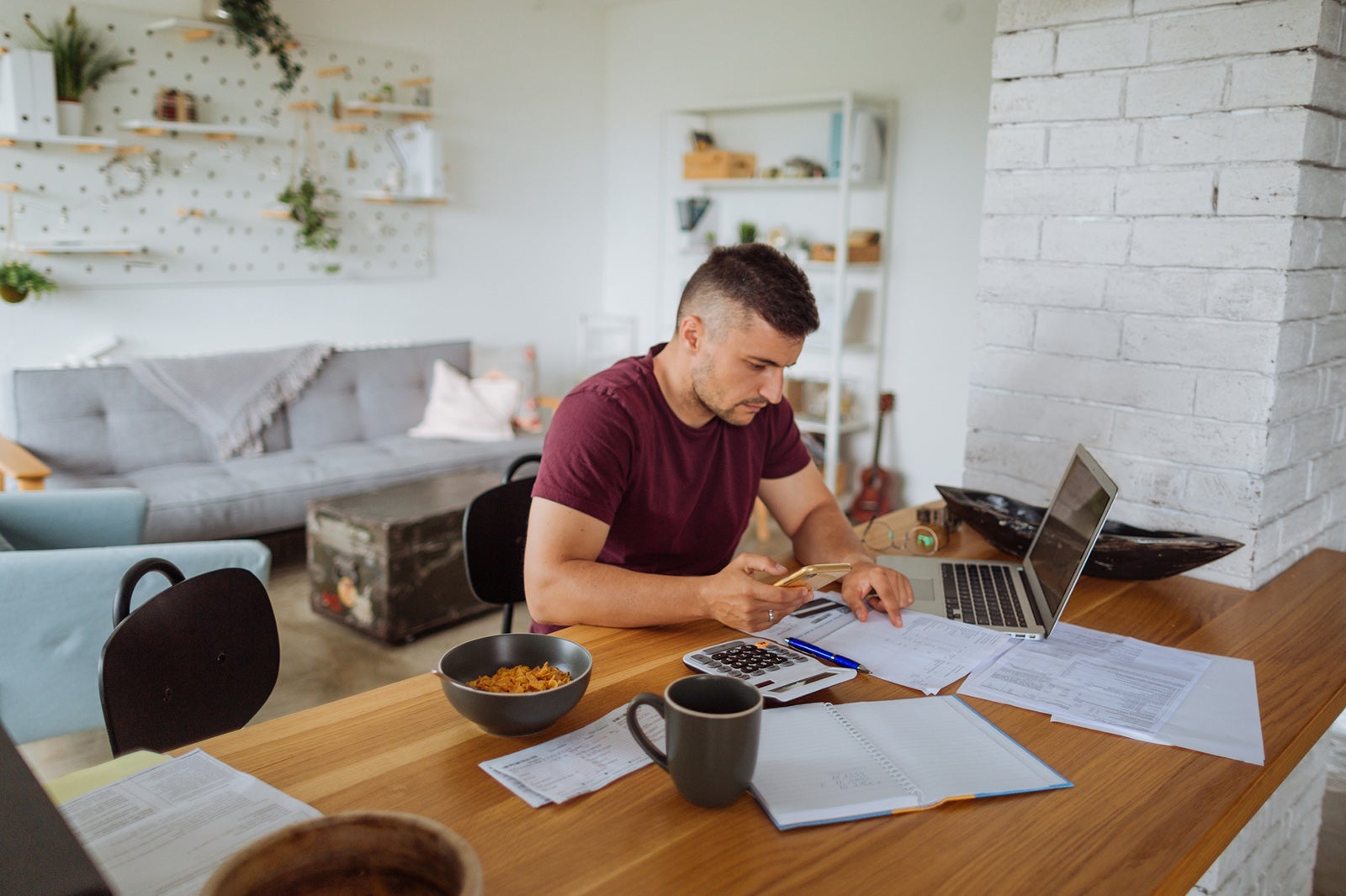 Young man at home, paying bills online