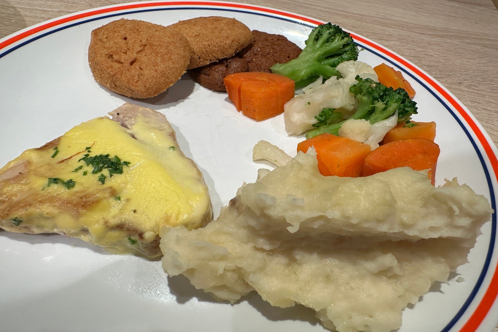 A white plate with fish, veggies and mashed potatoes