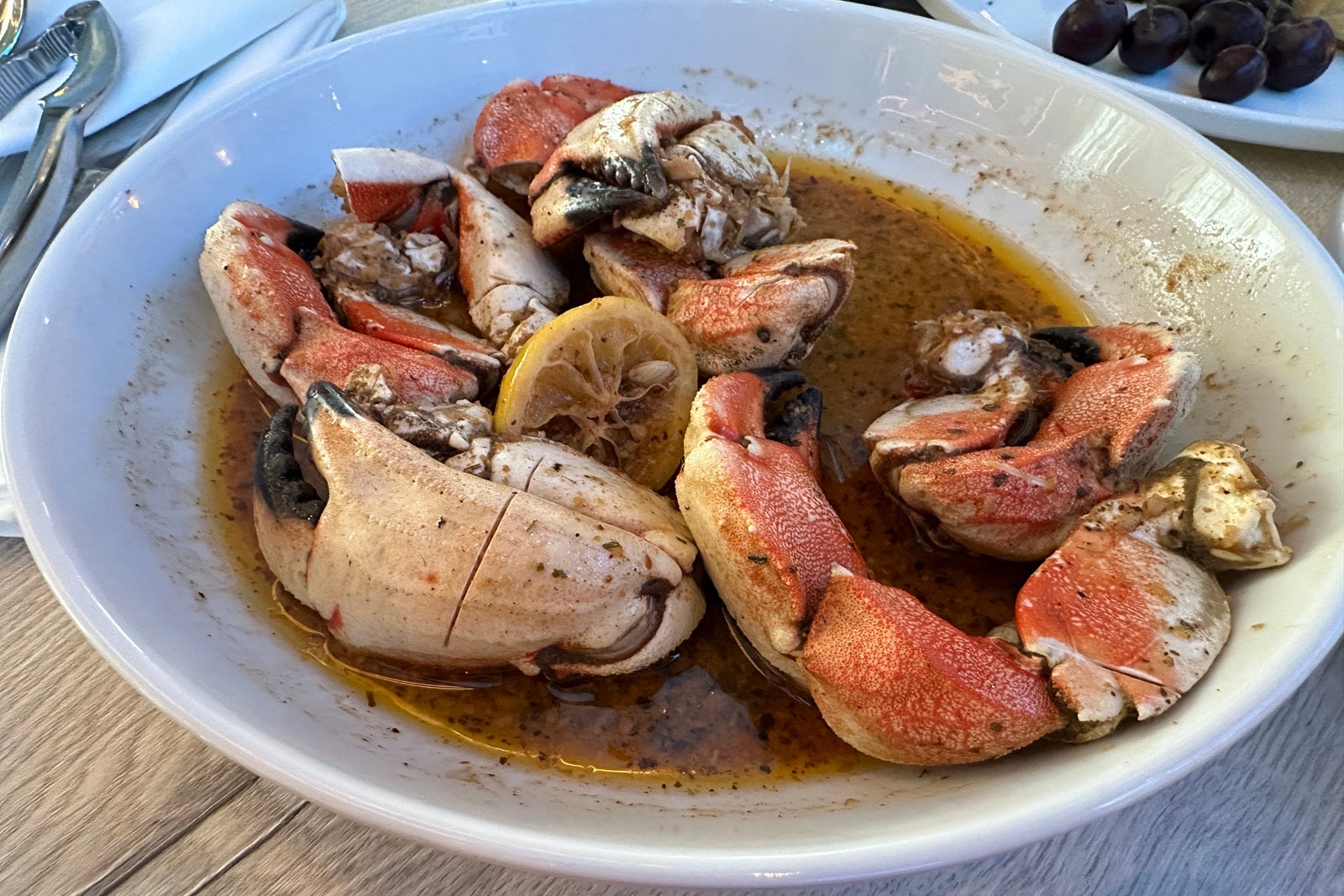A bowl filled with buttered crab claws and lemons