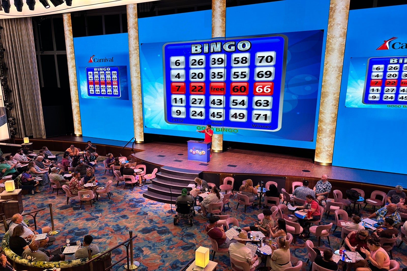 Cruise passengers playing bingo with the numbers displayed on a giant LED screen
