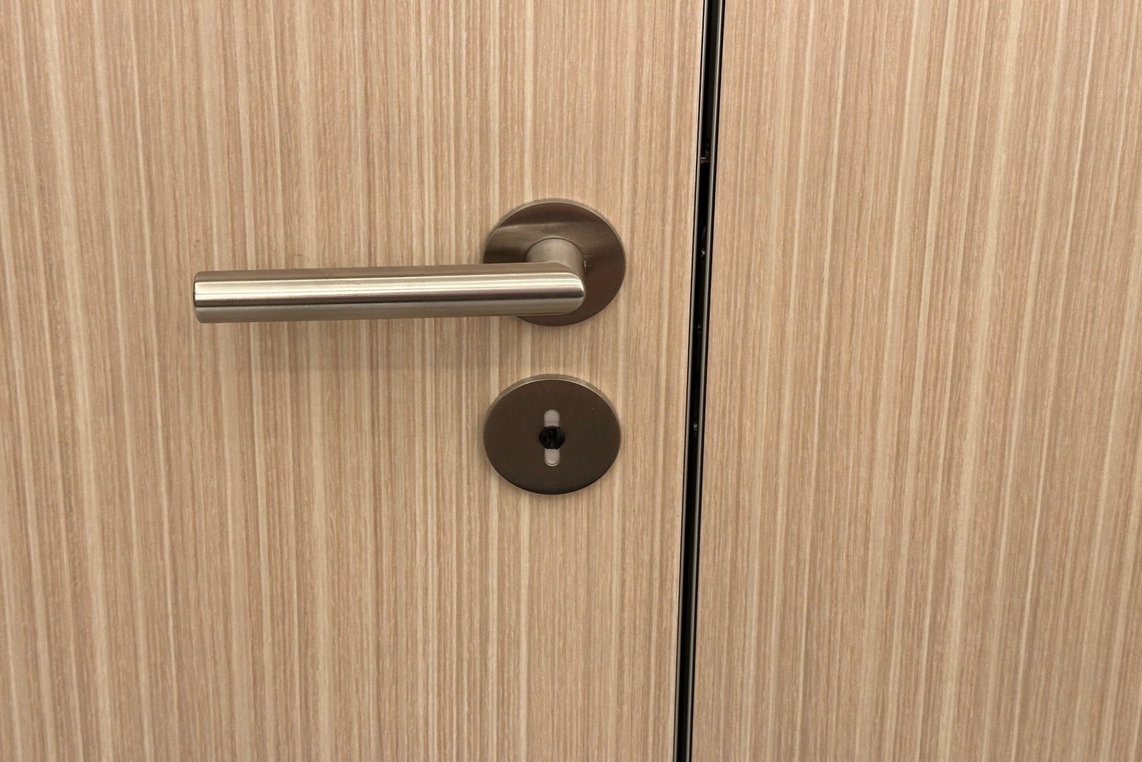 A bathroom stall door handle showing white for unoccupied