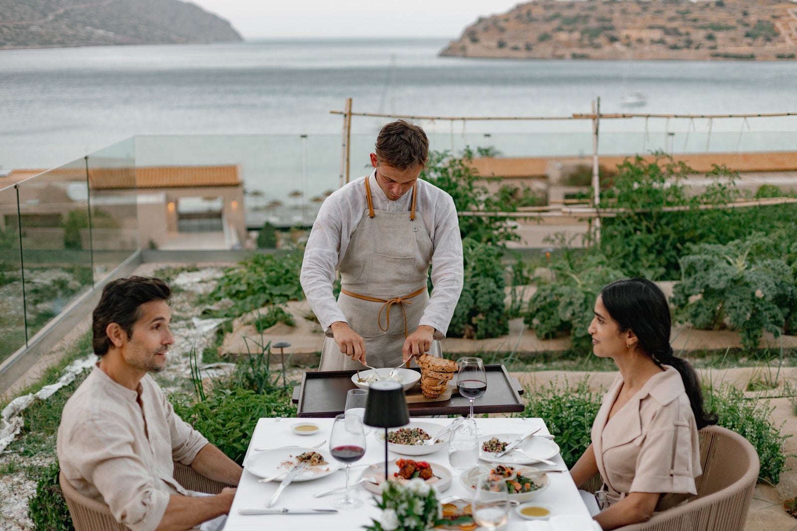 Two people dining and a waiter at the table