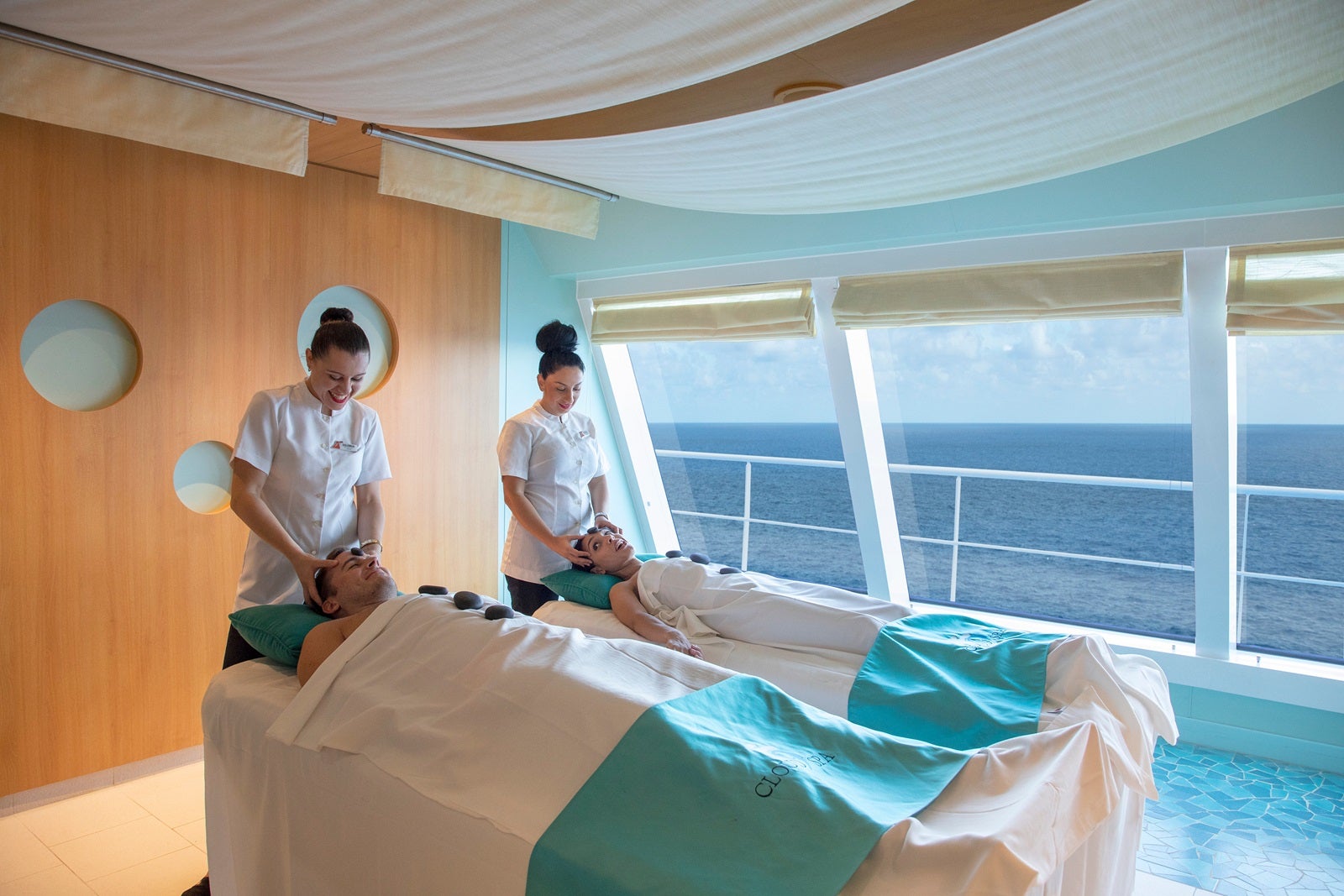 Two spa therapists performing a couples massage