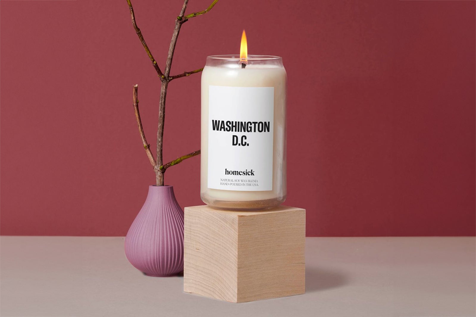 a white candle in a glass jar with "Washington D.C." on the label