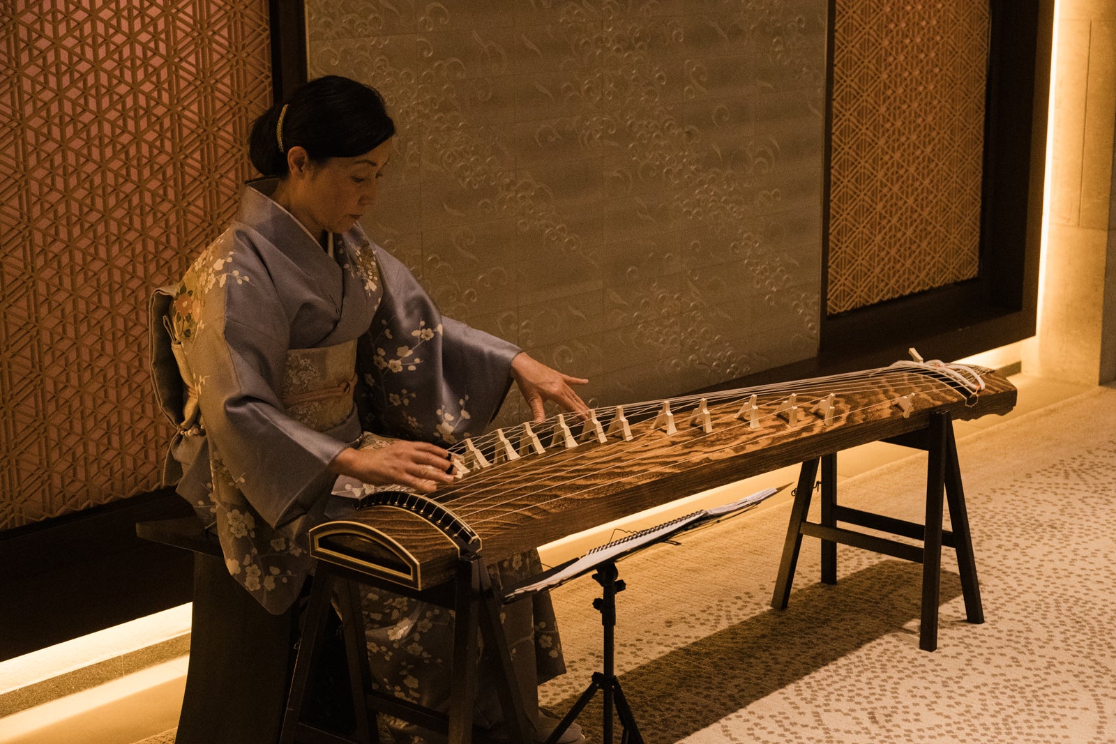 woman playing traditional koto stringed instrument at The Ritz-Carlton, Kyoto