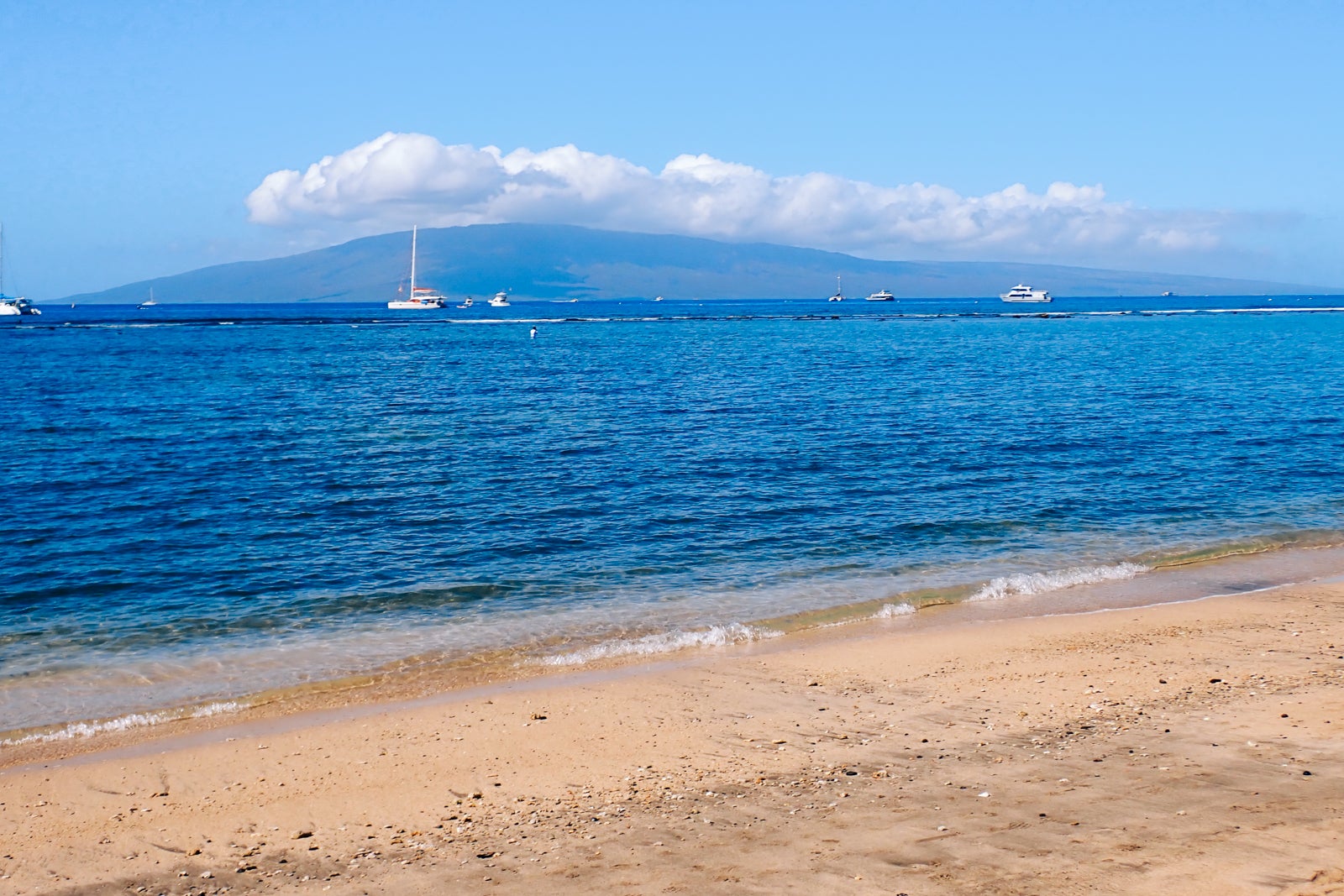 View of boats and distant island from beach