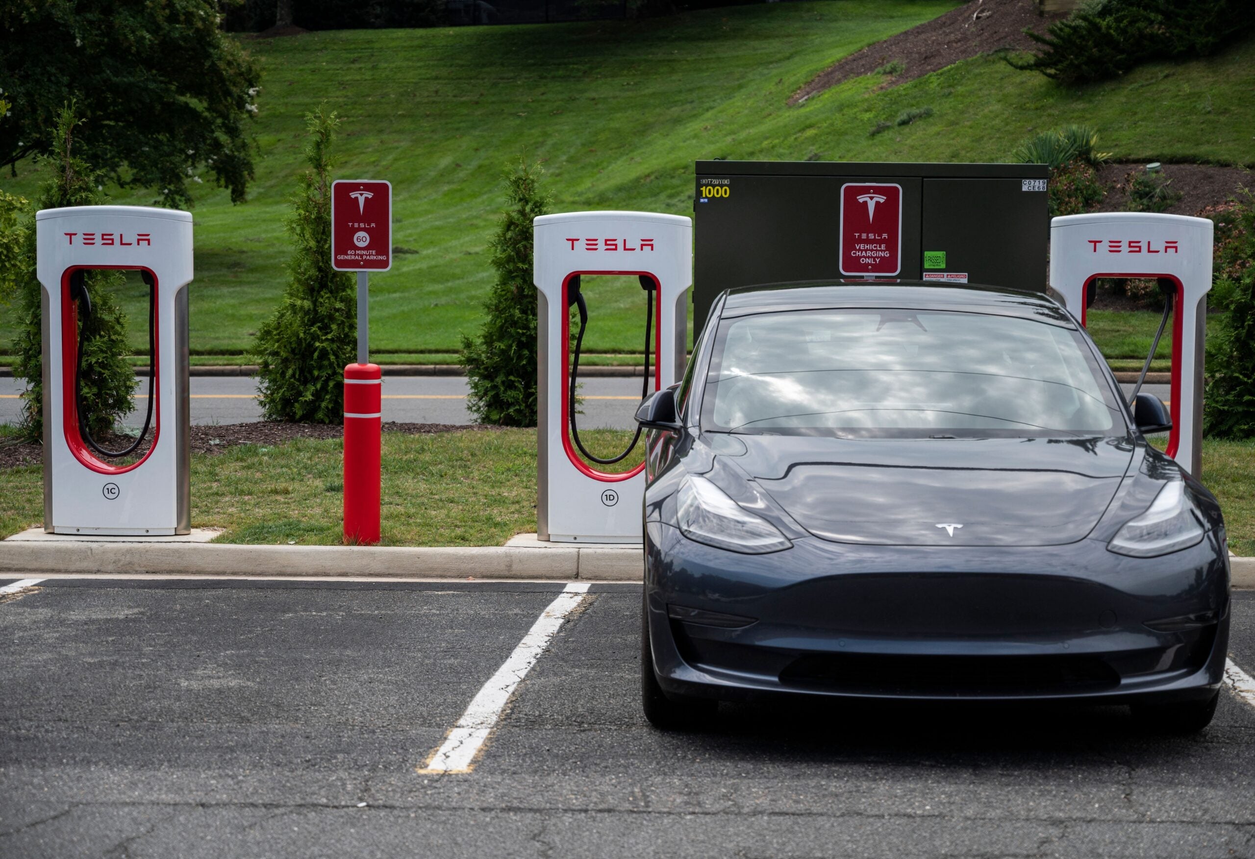 Cars charge at a Tesla super charging station in Arlington, Virginia on August 13, 2021. - The US Senate recently passed a bipartisan infrastructure bill that would spend $65 billion to improve the reliability and resiliency of the nations power grid, and would spend USD 55 billion on water and wastewater infrastructure. (Photo by ANDREW CABALLERO-REYNOLDS / AFP) (Photo by ANDREW CABALLERO-REYNOLDS/AFP via Getty Images)