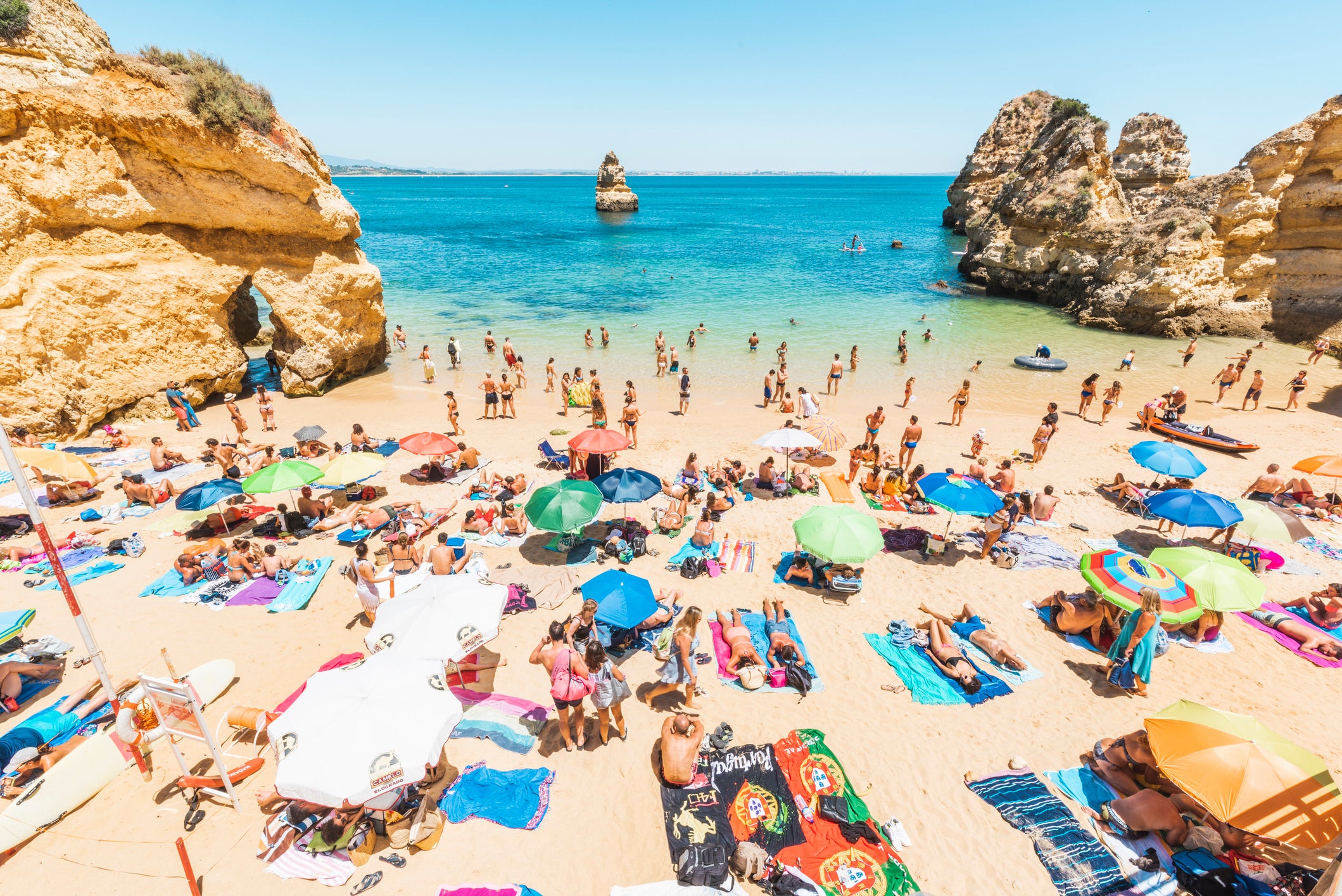 Tourists sunbathing in Praia do Camilo, Portugal