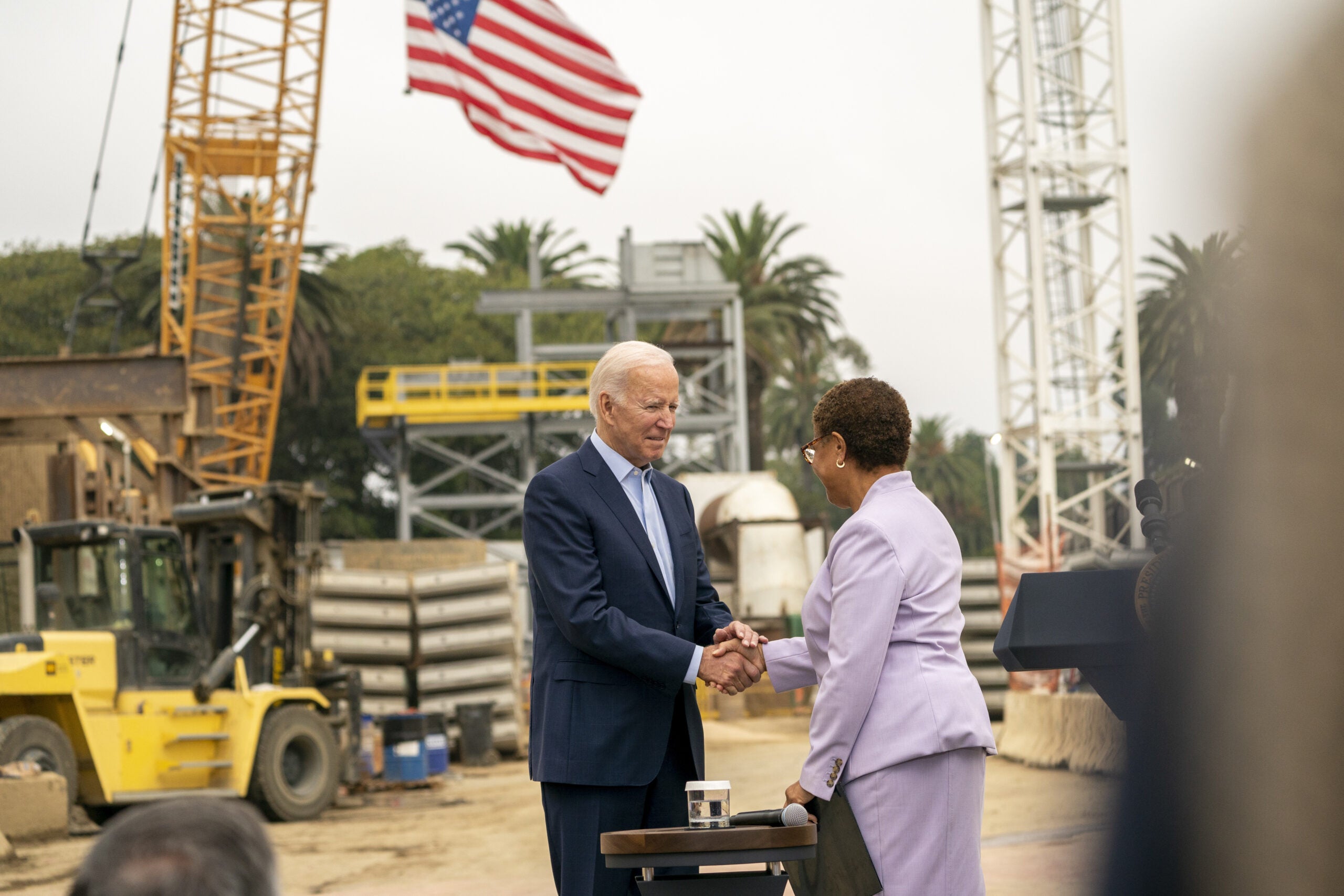 US President Joe Biden, left, shakes hands with Representative Karen Bass, a Democrat from California, before speaking at Los Angeles Metro's Purple (D Line) Extension Transit Project in Los Angeles, California, US, on Thursday, Oct. 13, 2022. The $550 billion bipartisan infrastructure bill that was signed into law last year includes billions in investments for roads, rail, and ports, as Biden has touted the bill as a measure that will ease bottlenecks driving inflation over the long term. Photographer: Kyle Grillot/Bloomberg via Getty Images