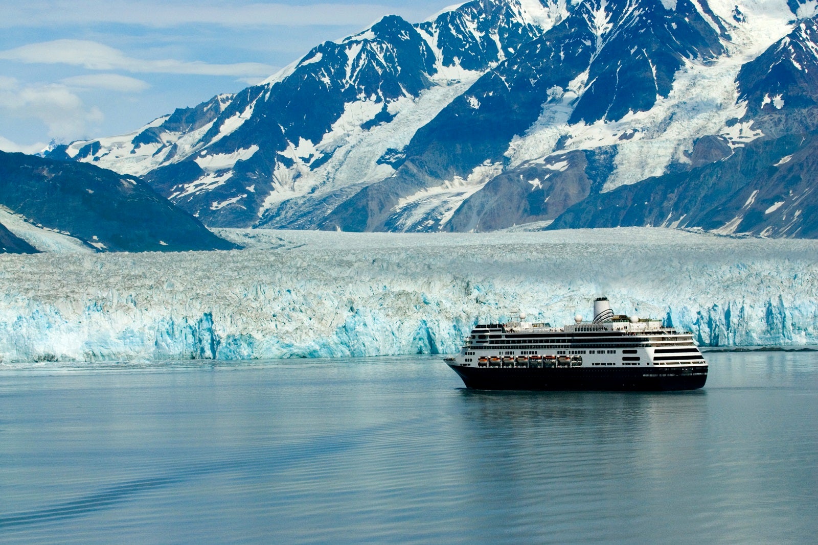 A Holland America ship anchored in front of a glacier in Alaska