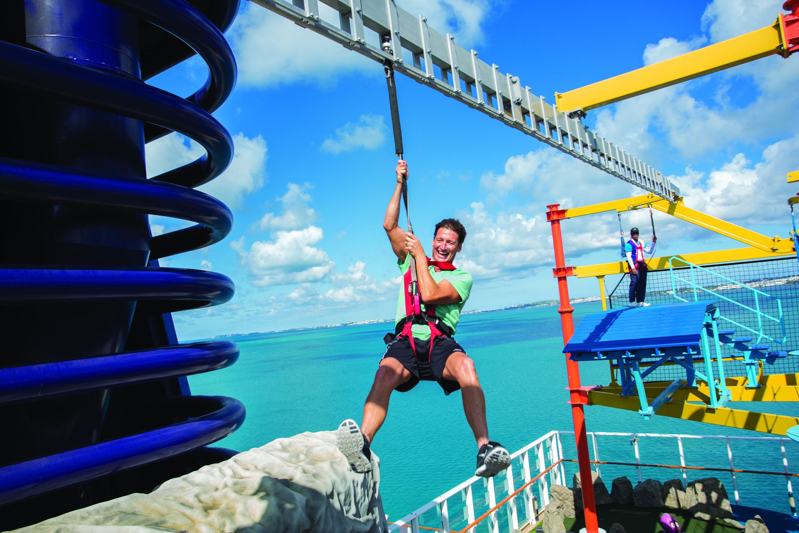 A cruise passenger in a harness on the zip line of a cruise ship ropes course