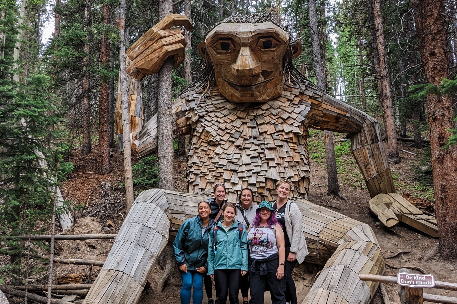 Six female hikers posing by giant troll in Breckenridge, CO