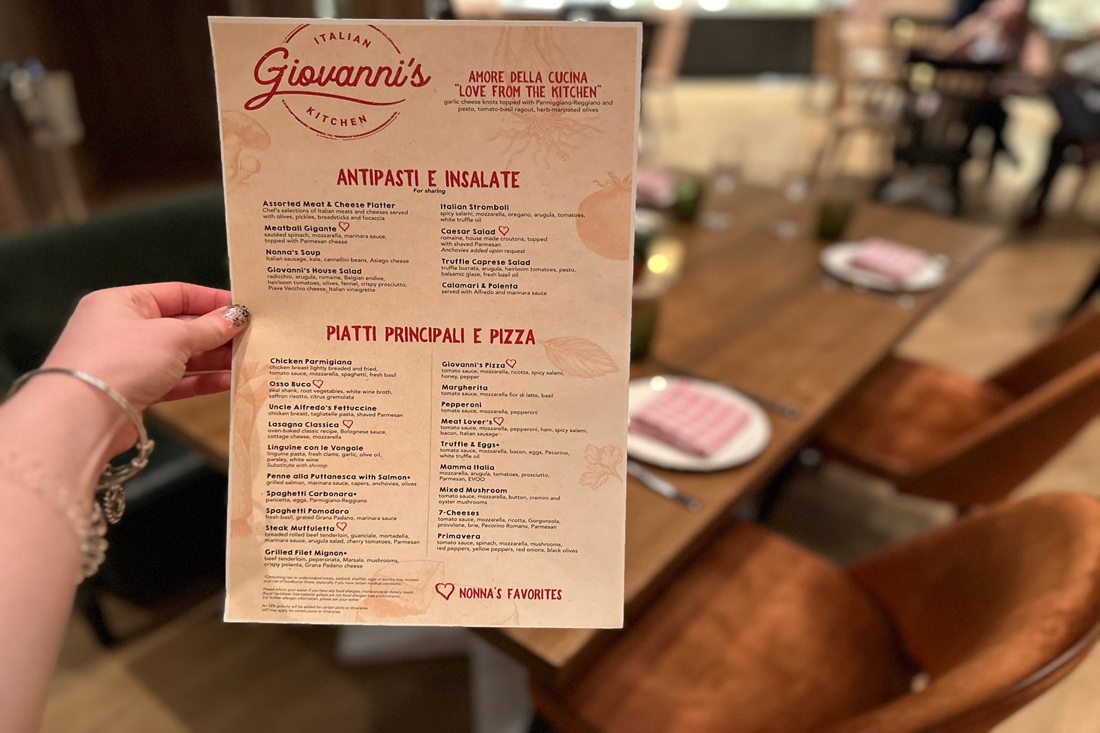 A hand holding an Italian restaurant menu