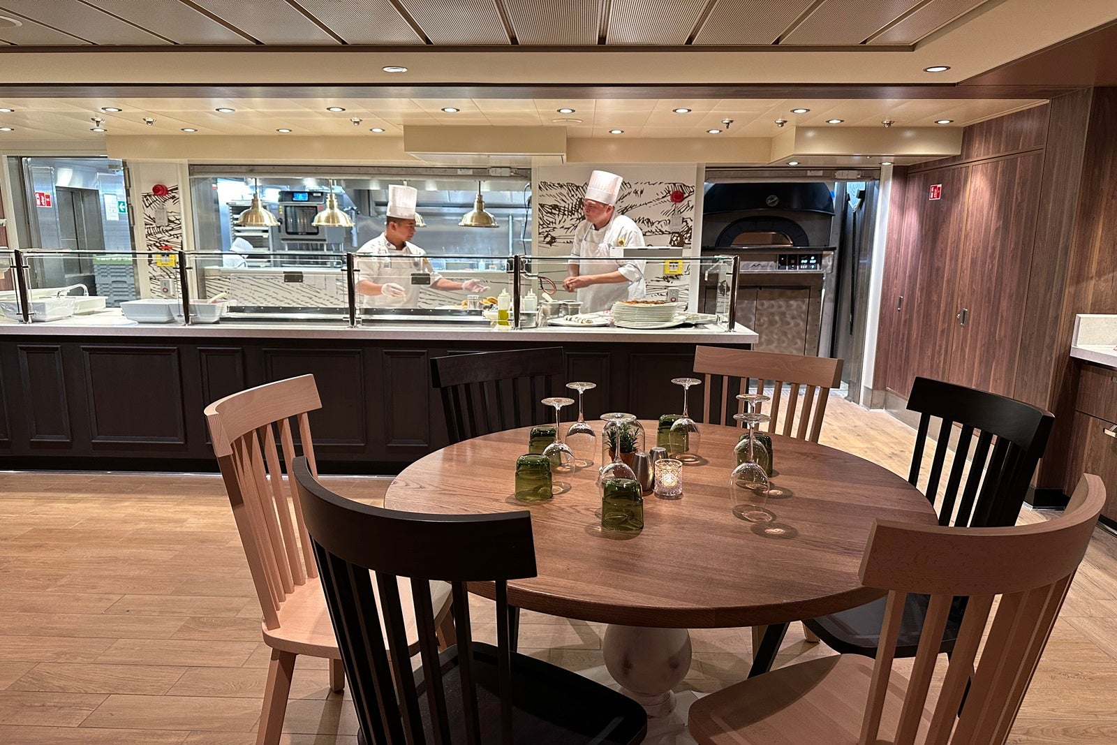 Chefs prepare dinner behind a counter at an Italian restaurant