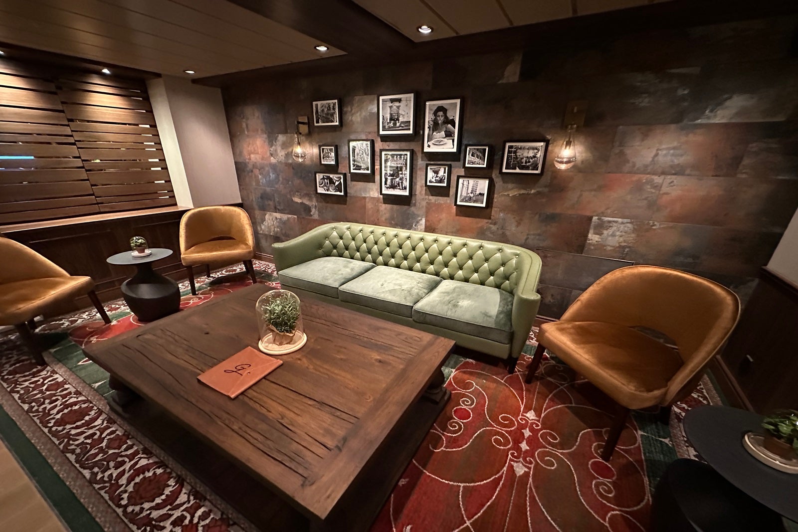 A lounge area in a cruise ship bar with a couch, table and chairs