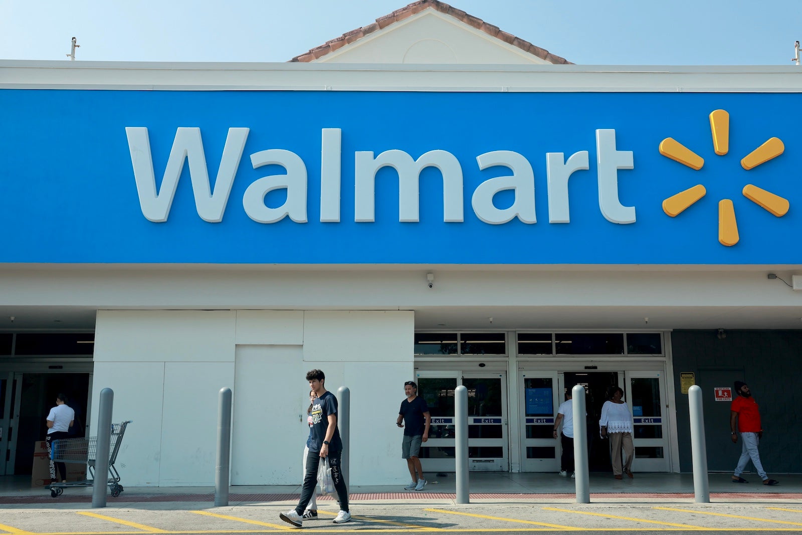 People walk near the entrance to a Walmart store on May 14, 2024 in Miami, Florida.