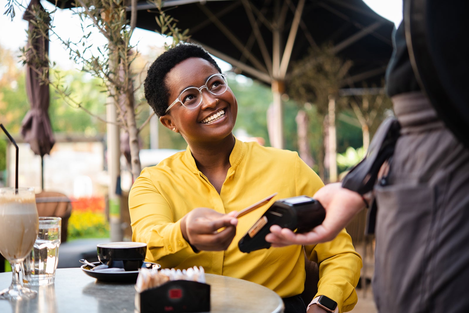 African American young woman paying with a credit card for her coffee