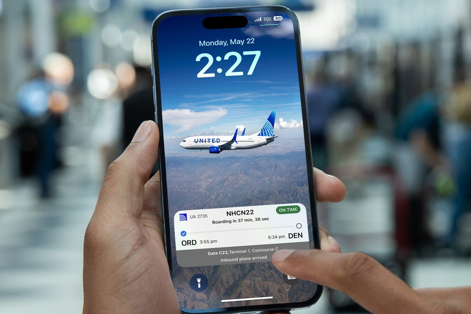 A person using an iphone with the united app on it 
