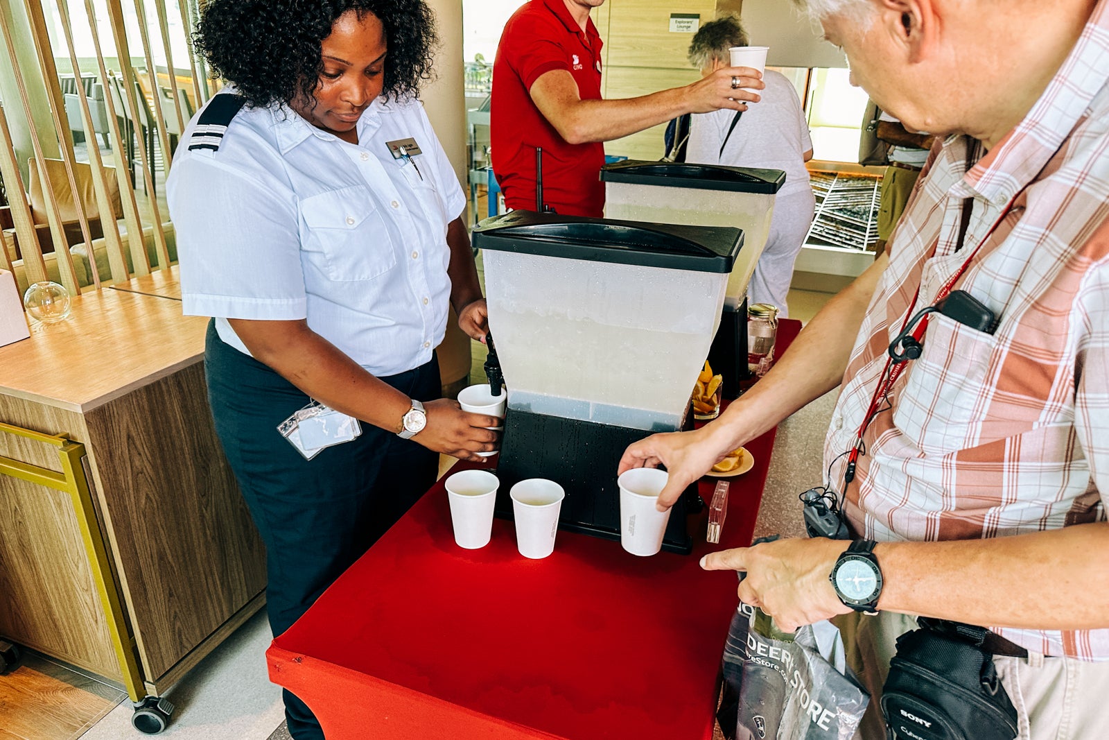 Crew members offer cold drinks to cruise passengers after a hot day ashore