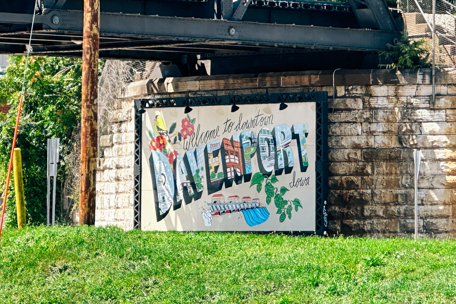 A Davenport, Iowa, welcome sign painted on a brick wall under a bridge