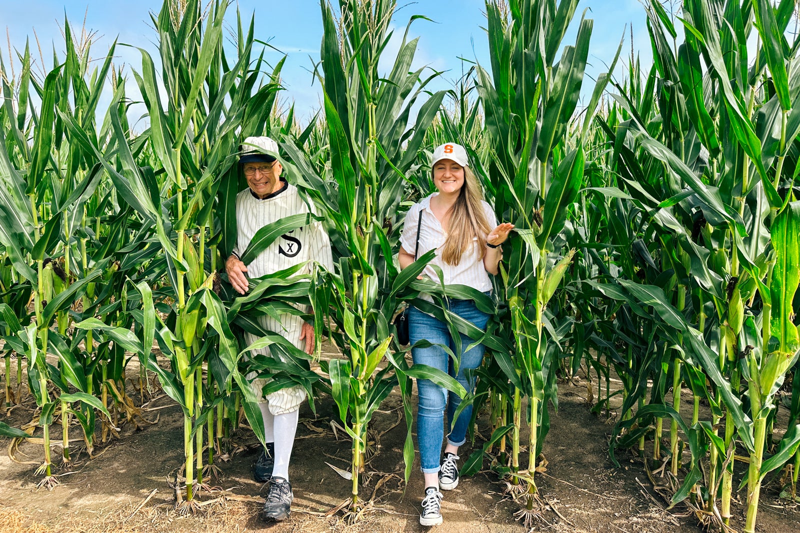 Two people walking out of a corn field