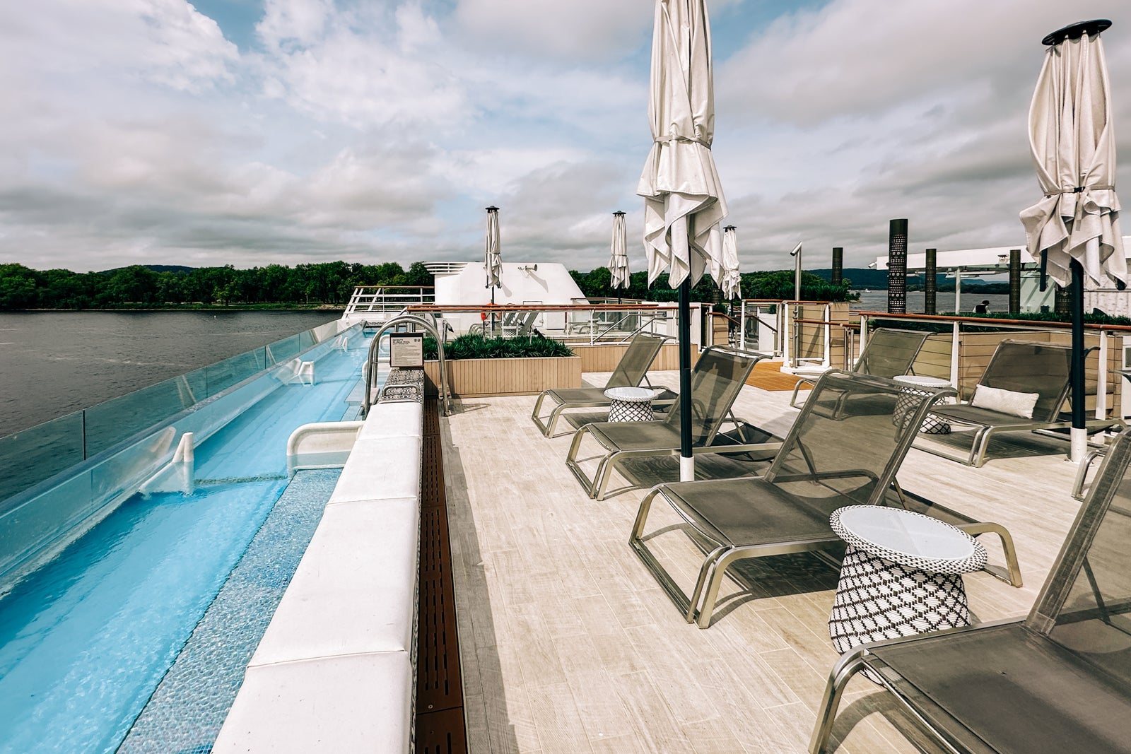 A long, skinny pool for soaking and staring out over the back of a cruise ship with loungers nearby