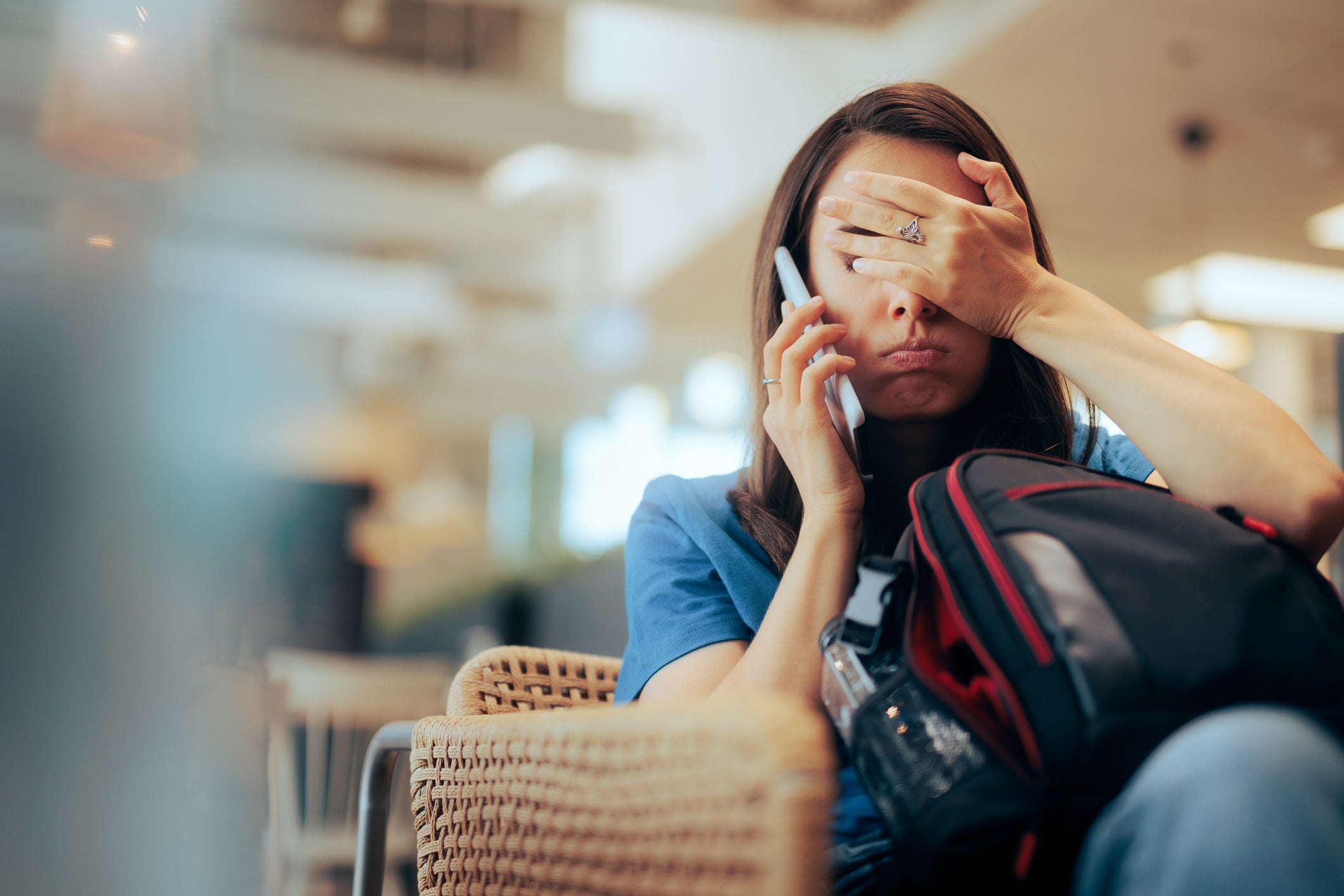 Unhappy Woman Talking on the Phone Waiting in an Airport