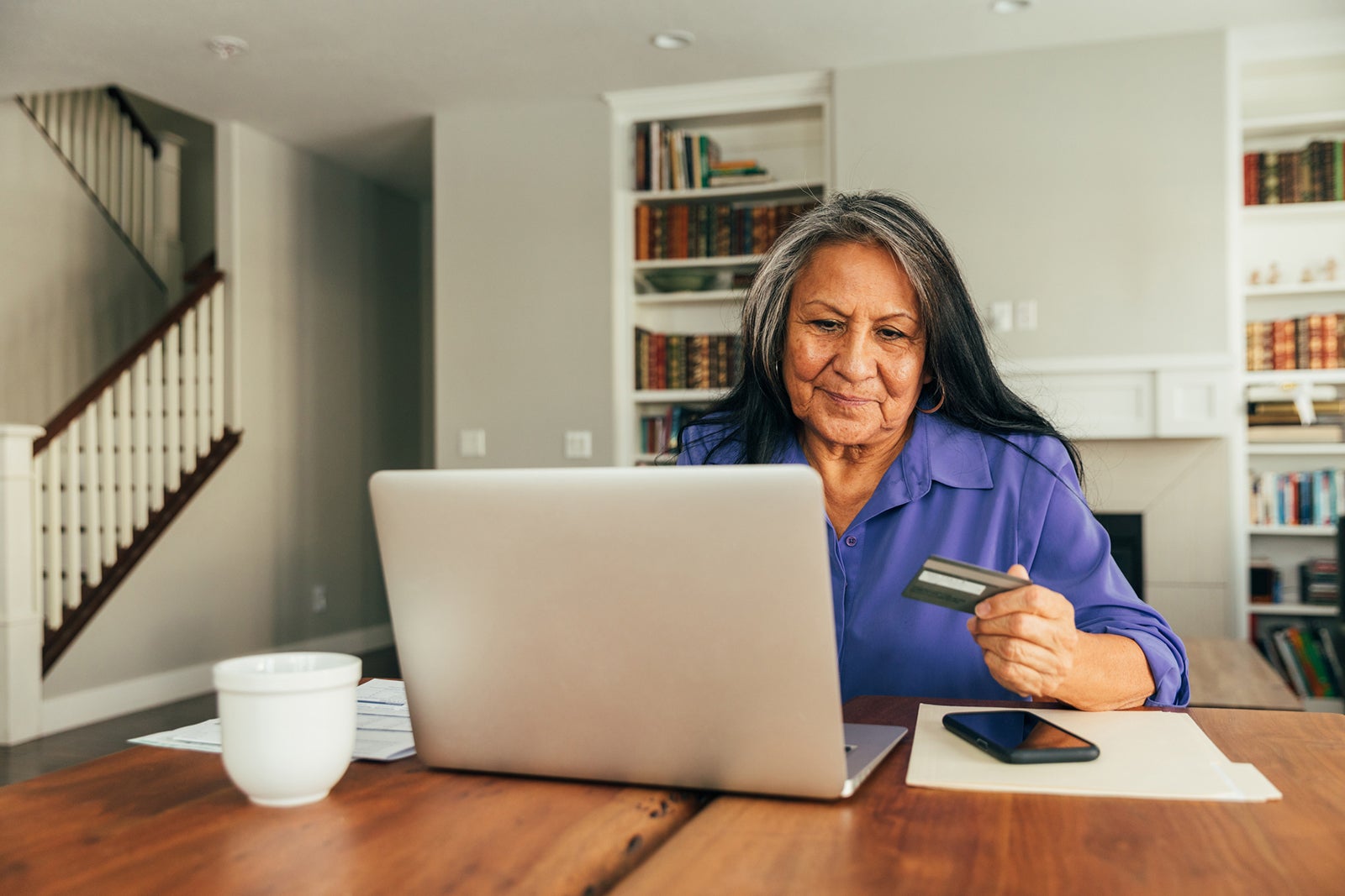 Older woman at her laptop with a credit card and phone