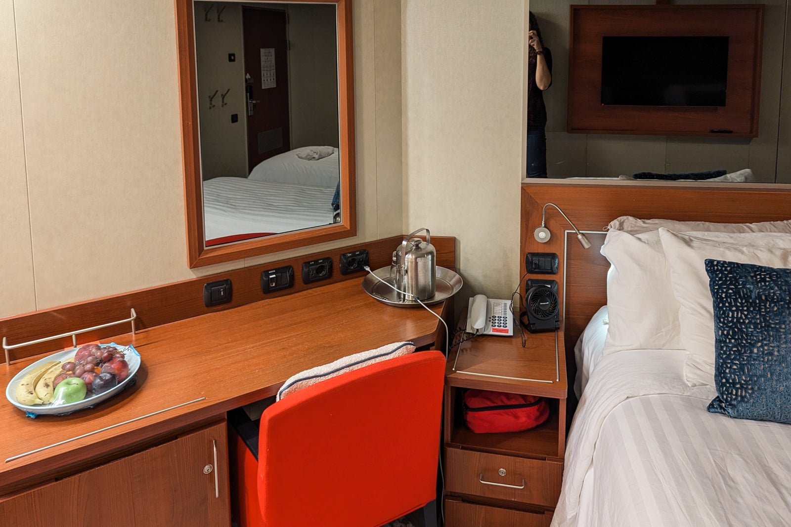 Desk with red chair and bed on a cruise ship