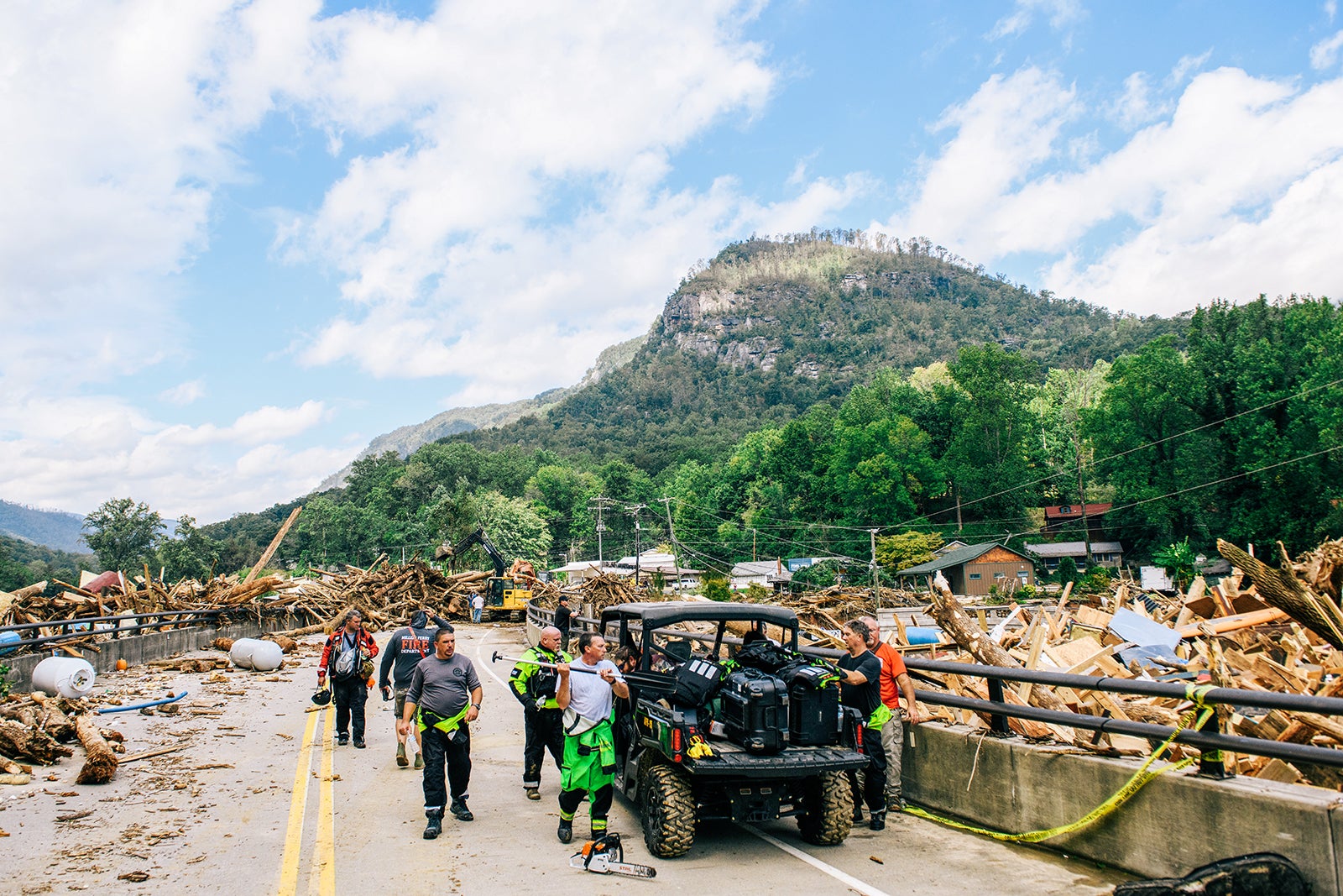 Emergency personnel are observed on a road as the Rocky Broad River merges into Lake Lure, carrying debris from Chimney Rock, North Carolina, after heavy rains caused by Hurricane Helene on September 28, 2024, in Lake Lure, North Carolina. 