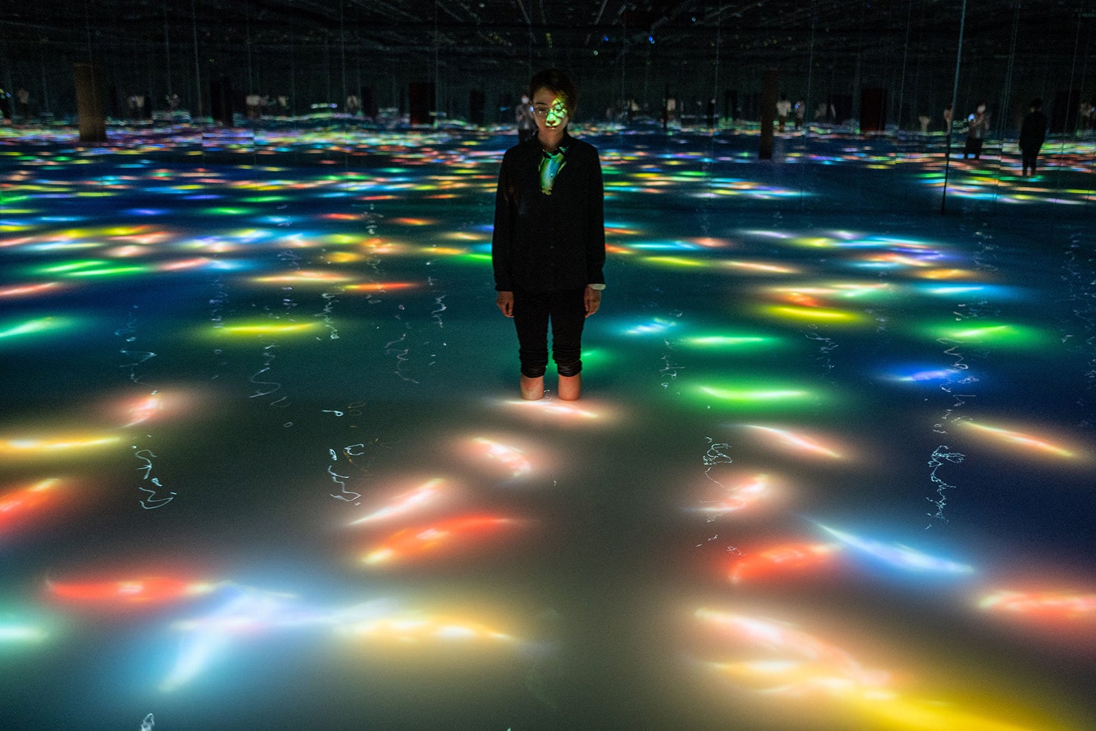 A person standing in the TeamLab Planets Water Area