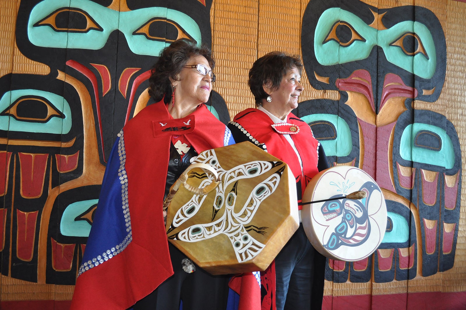 Two dancers in Tlingit dress with drums