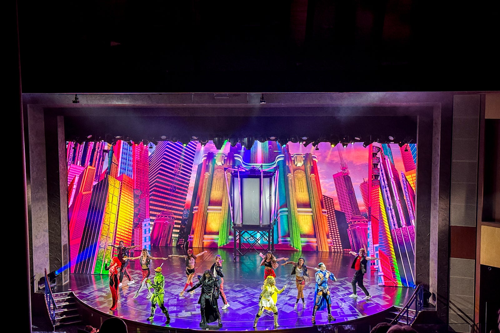 A colorful cruise ship production show featuring singing and dancing superheroes